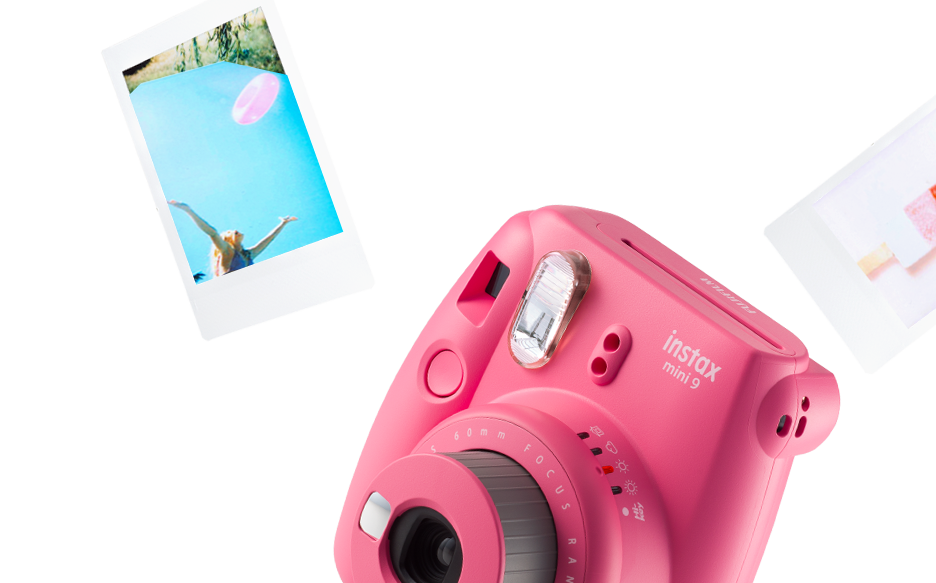 粉色即影即有相機與照片 壁紙 — 一部鮮豔的粉紅色Instax Mini 9相機，周圍漂浮著即時照片，背景為純白色。