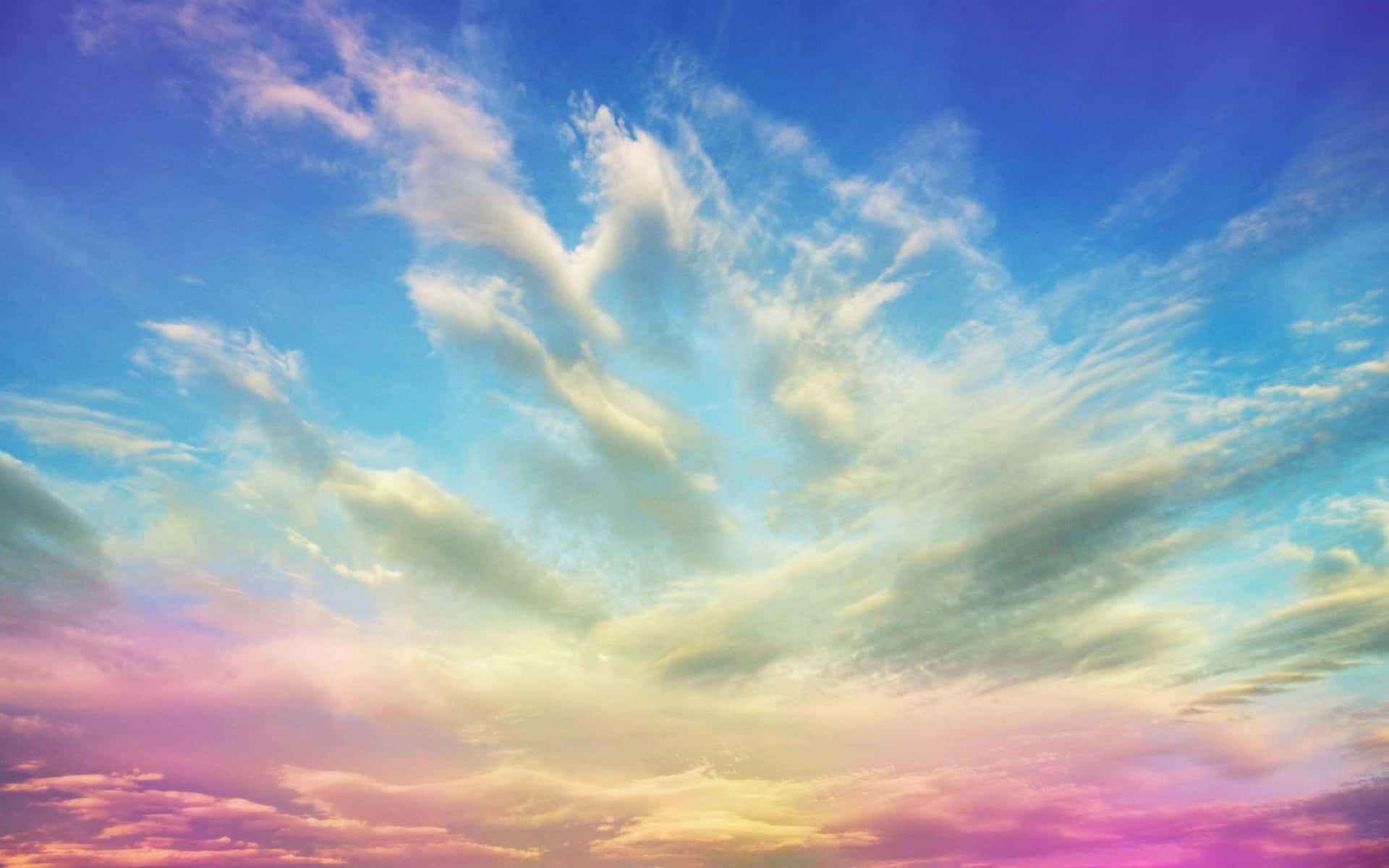 粉彩日落天空，薄雲呈現粉紅、黃和藍色調。
