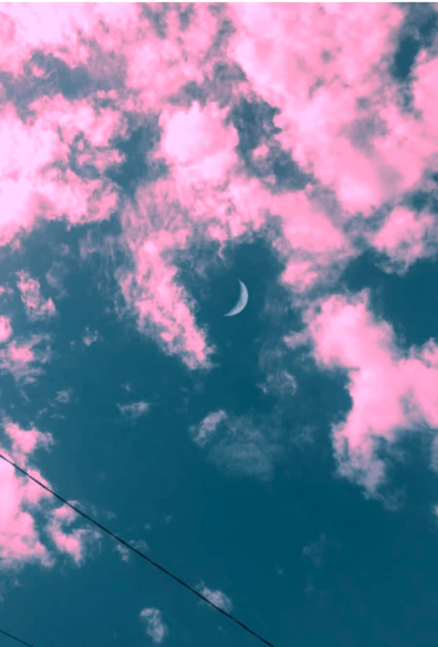 粉紅和藍綠色天空中的新月與縷縷雲彩
