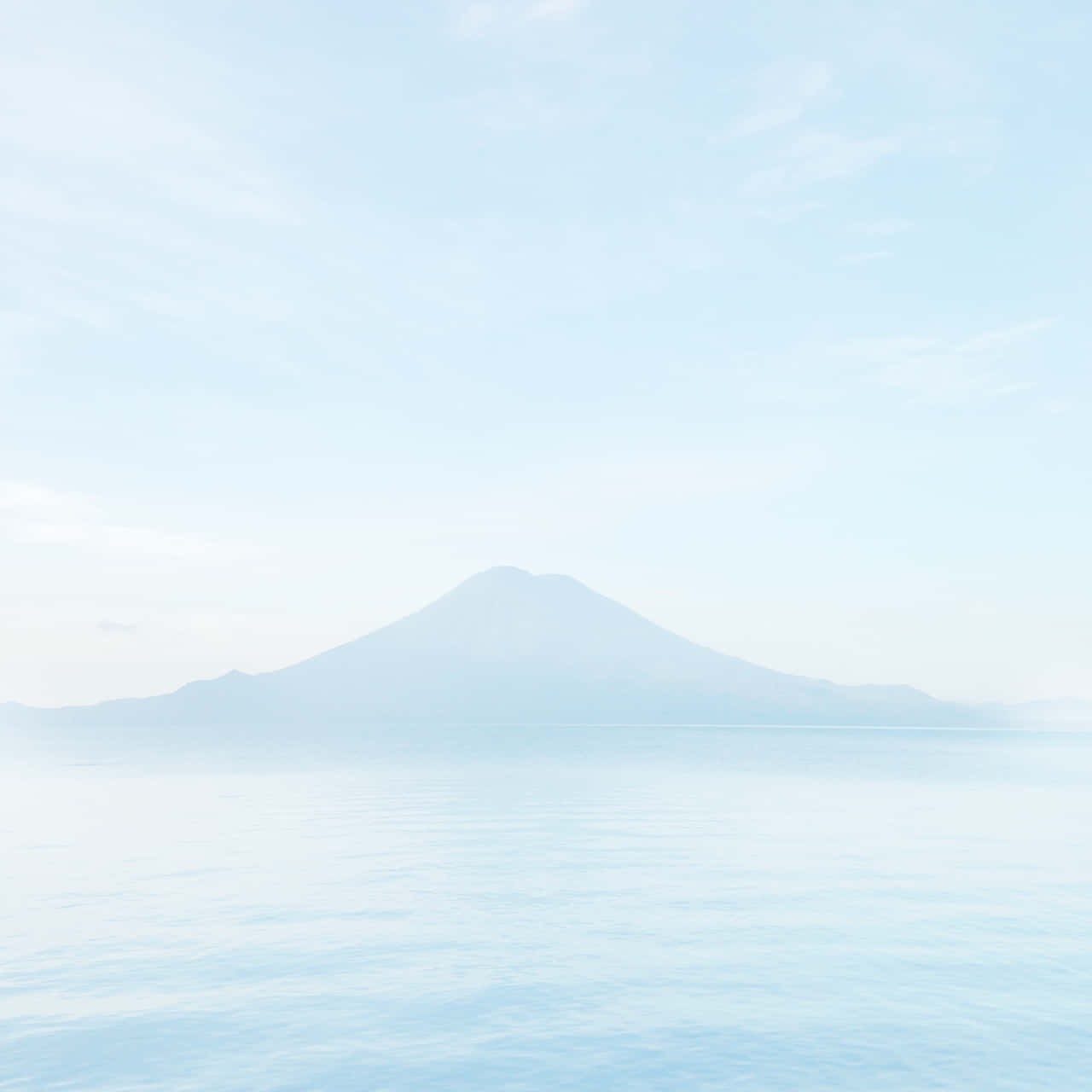 粉藍調富士山壁紙 壁紙 — 一座寧靜的山從平靜的水面升起，在柔和的藍天下飄著縷縷白雲。