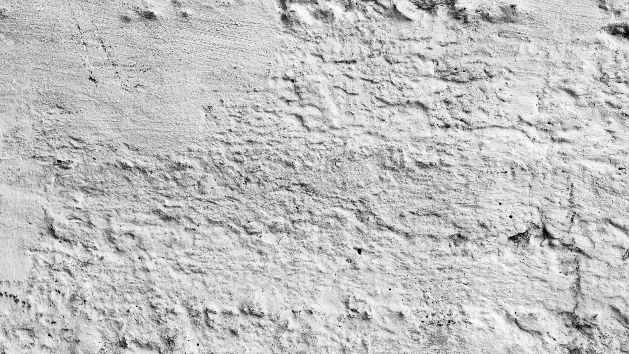 Wall Texture 桌布 壁紙 — 粗糙紋理白色灰泥牆的特寫，帶有細微的灰色變化和不均勻的筆觸。