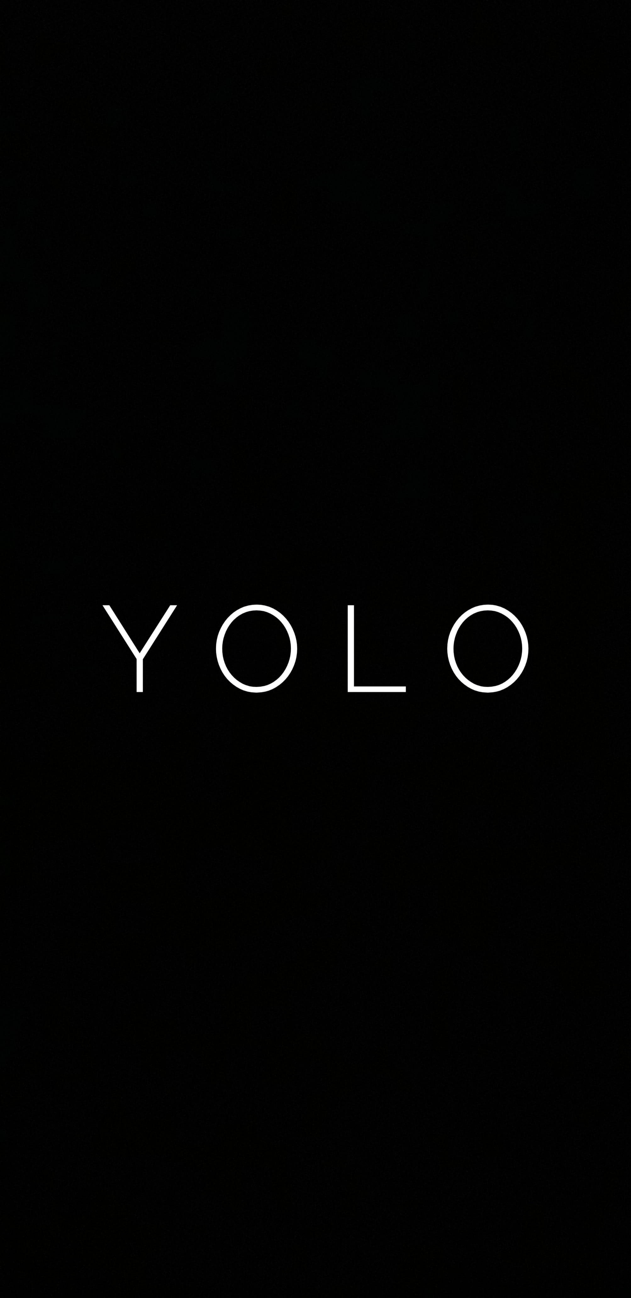 黑色動態圖 桌布 壁紙 — 粗體白色 'YOLO' 文字居中在純黑色背景上，營造出極簡的勵志語句。
