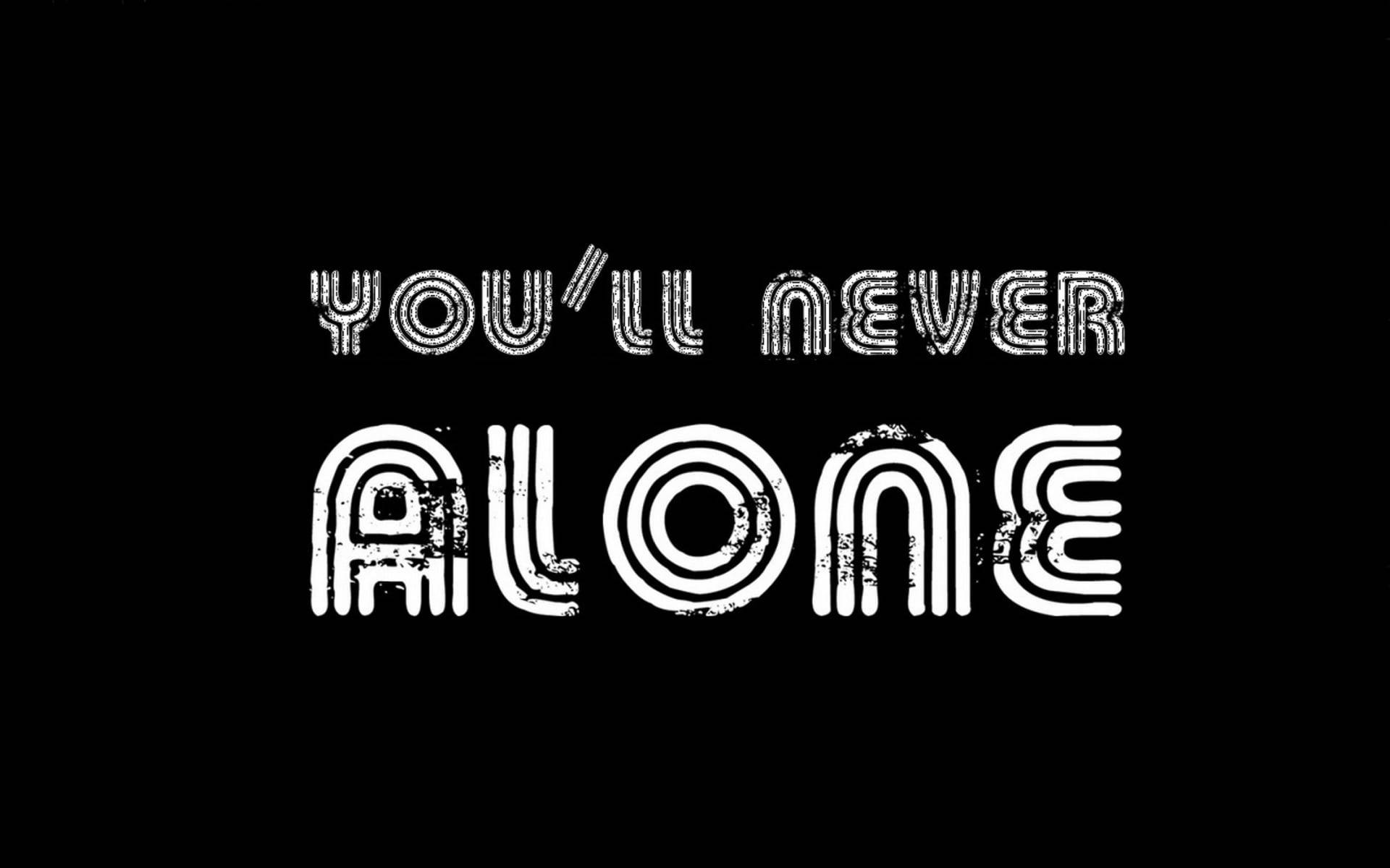語錄 桌布 壁紙 — 粗體白色破損字體在純黑背景上拼出「YOU'LL NEVER ALONE」。