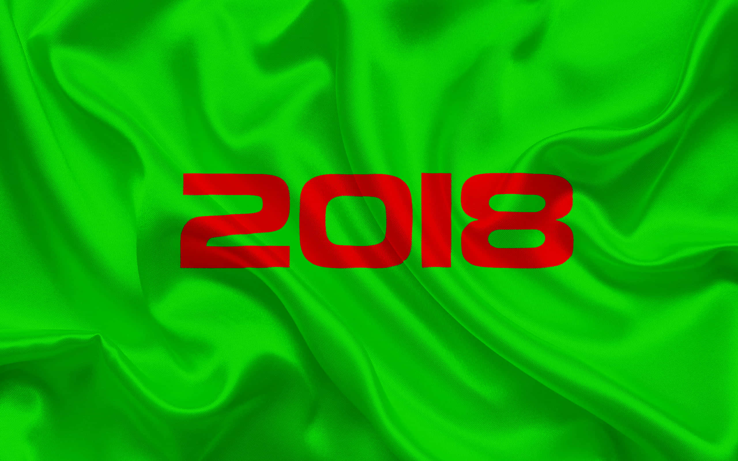 2018 桌布 壁紙 — 粗體紅色2018文字漂浮在充滿活力的綠色緞面布料上，帶有流動的褶皺和光澤亮點。
