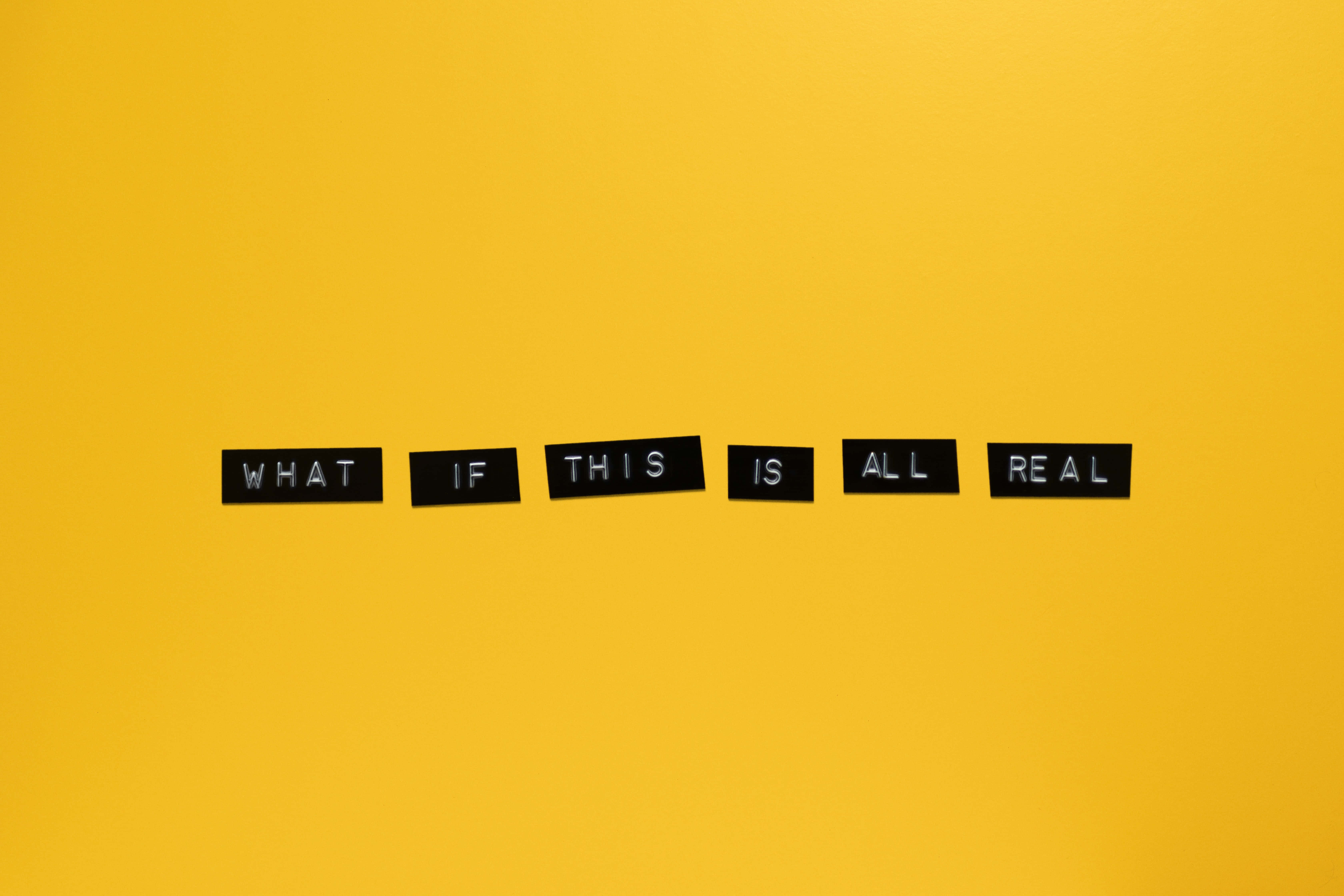 Vector Art 桌布 壁紙 — 粗體黑色字母瓷磚在鮮黃色背景上拼出「WHAT IF THIS IS ALL REAL」。