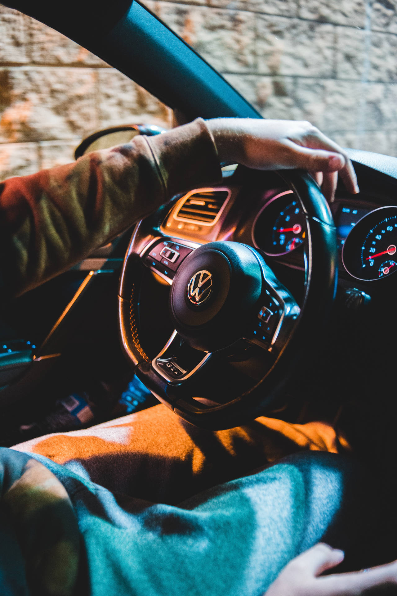 夜間駕駛福士汽車的人，車內溫暖照明，窗外磚牆景觀。