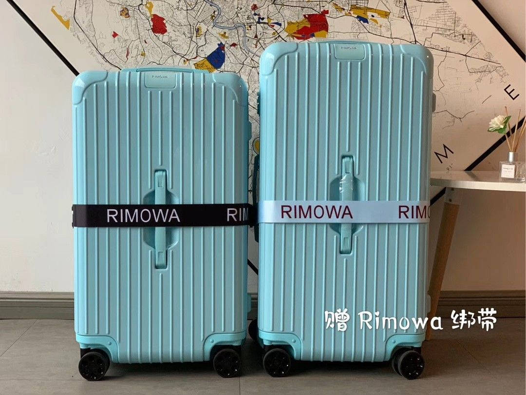 兩個淺藍色RIMOWA行李箱帶有品牌綁帶，放在地圖牆前。