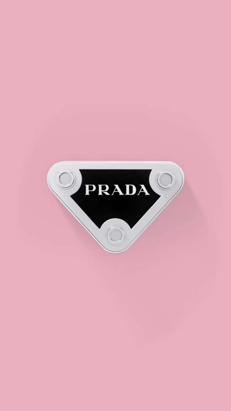 「精緻的時尚宣言」 壁紙 — 一個簡約的Prada標誌三角形，銀色和黑色，置於柔和的粉紅色背景中央。