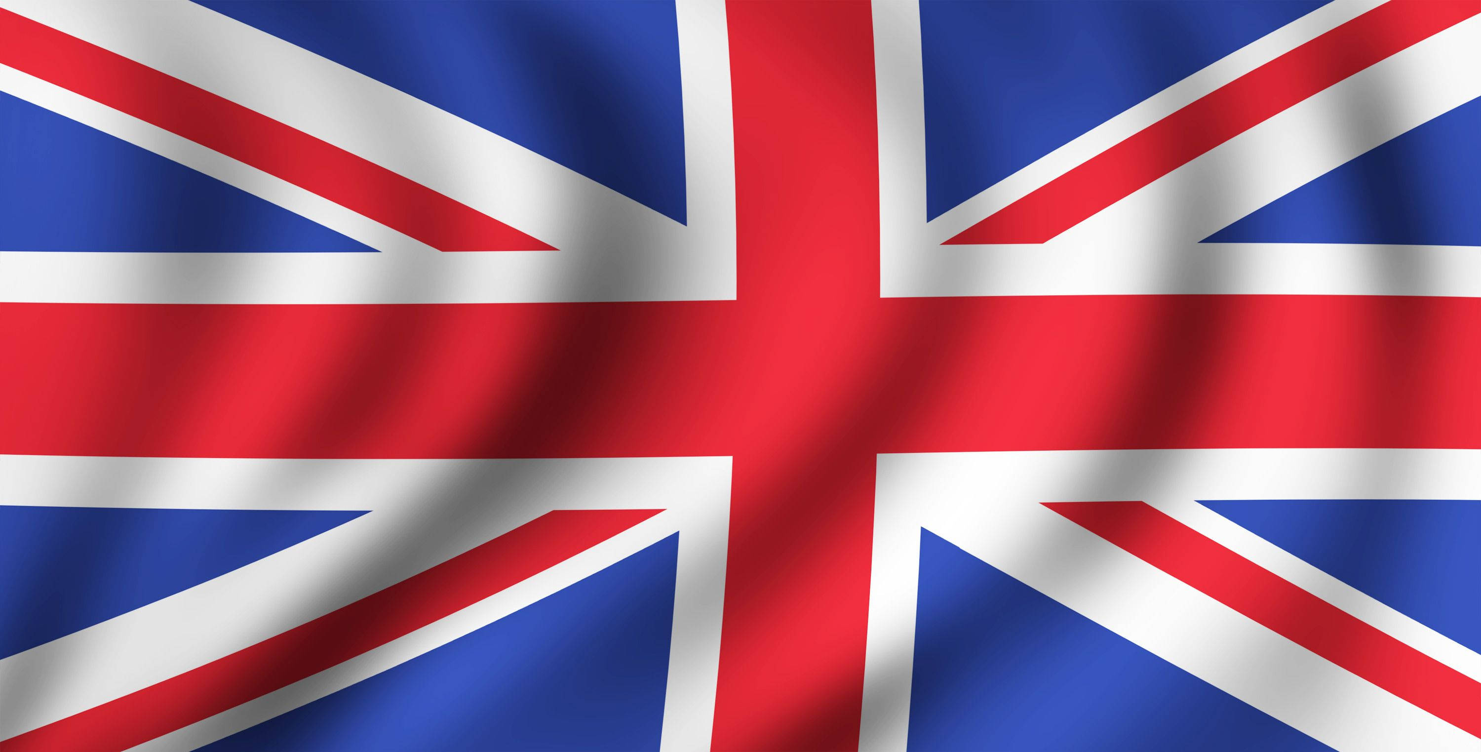 精緻英國國旗影像 壁紙 — 英國國旗在明亮的日光下以豐富的紅、藍、白色動態飄揚。
