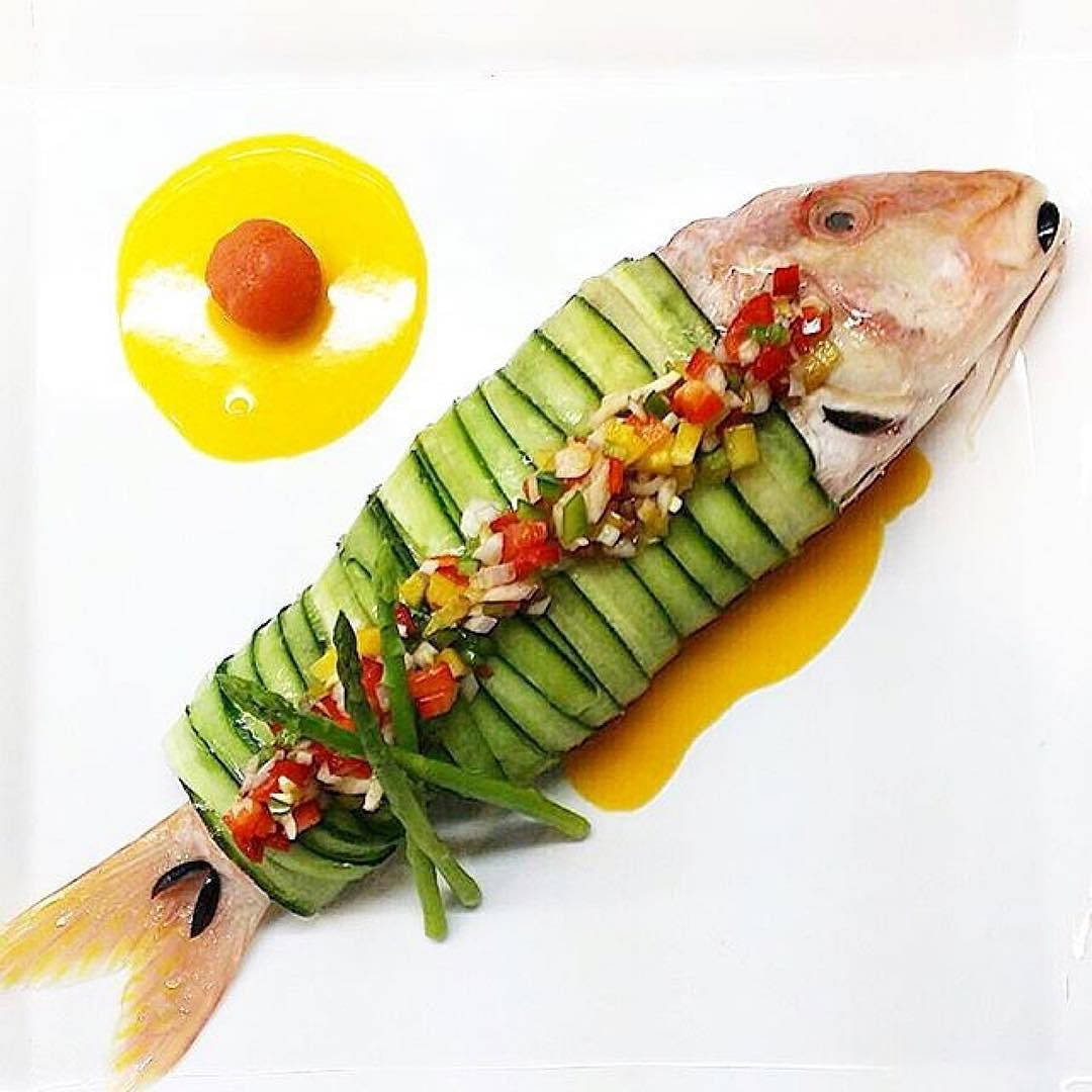 以青瓜包裹的精緻魚料理，配上色彩繽紛的蔬菜配料。