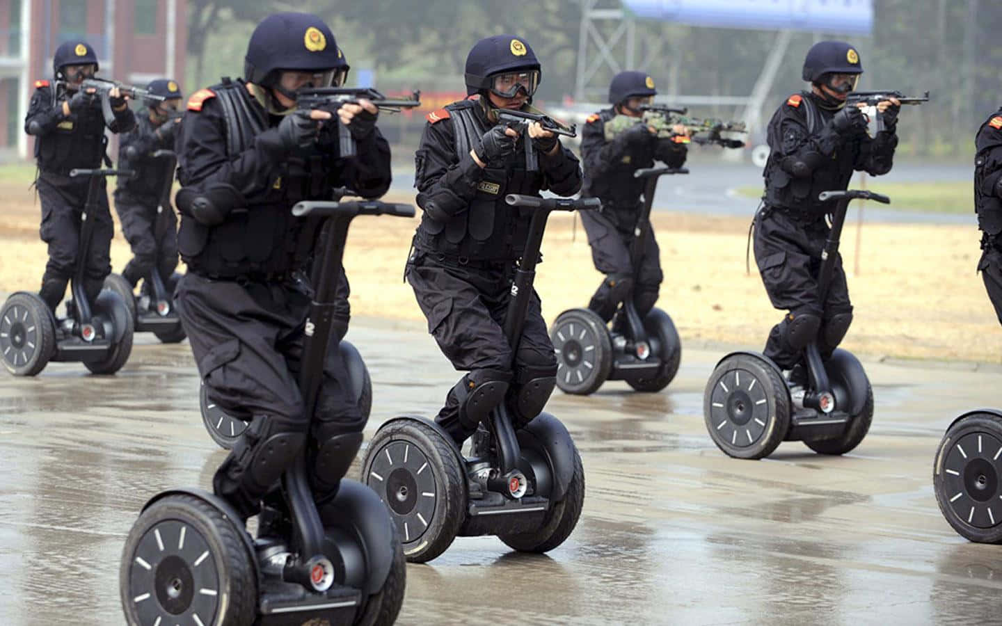 身穿戰術裝備的警員在戶外騎乘賽格威並瞄準步槍。