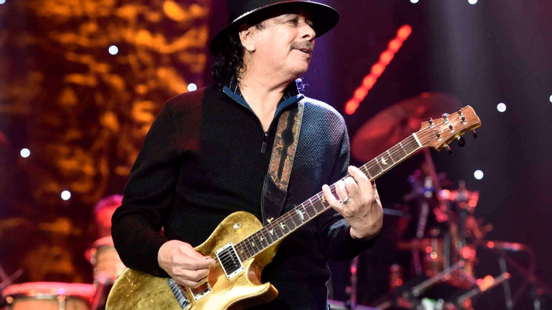 Carlos Santana 在現場音樂會中於舞台上演奏電結他。