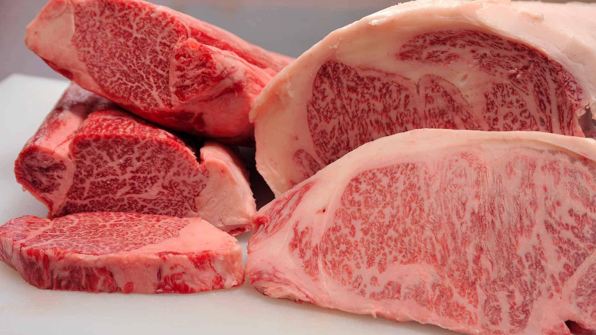 一堆高品質的大理石紋牛肉切塊，脂肪紋理清晰可見。
