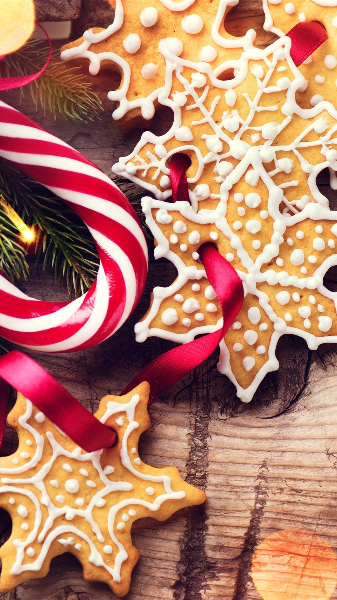 節日薑餅雪花曲奇，紅色絲帶，木質背景，拐杖糖和松樹。