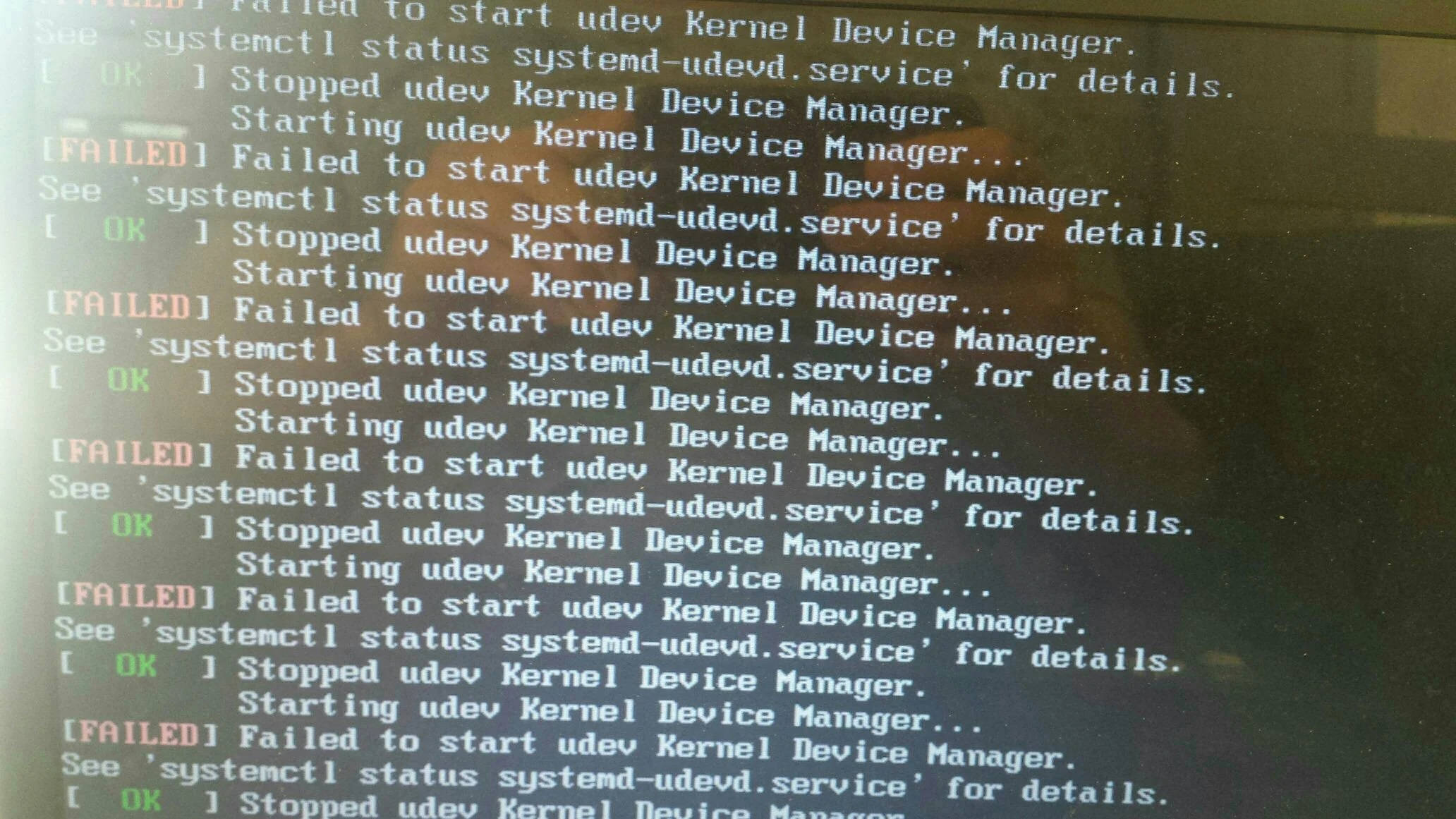 系統核心裝置管理器 壁紙 — 電腦屏幕特寫，顯示重複的 udev Kernel Device Manager 服務失敗錯誤訊息，白色文字在深色背景上。