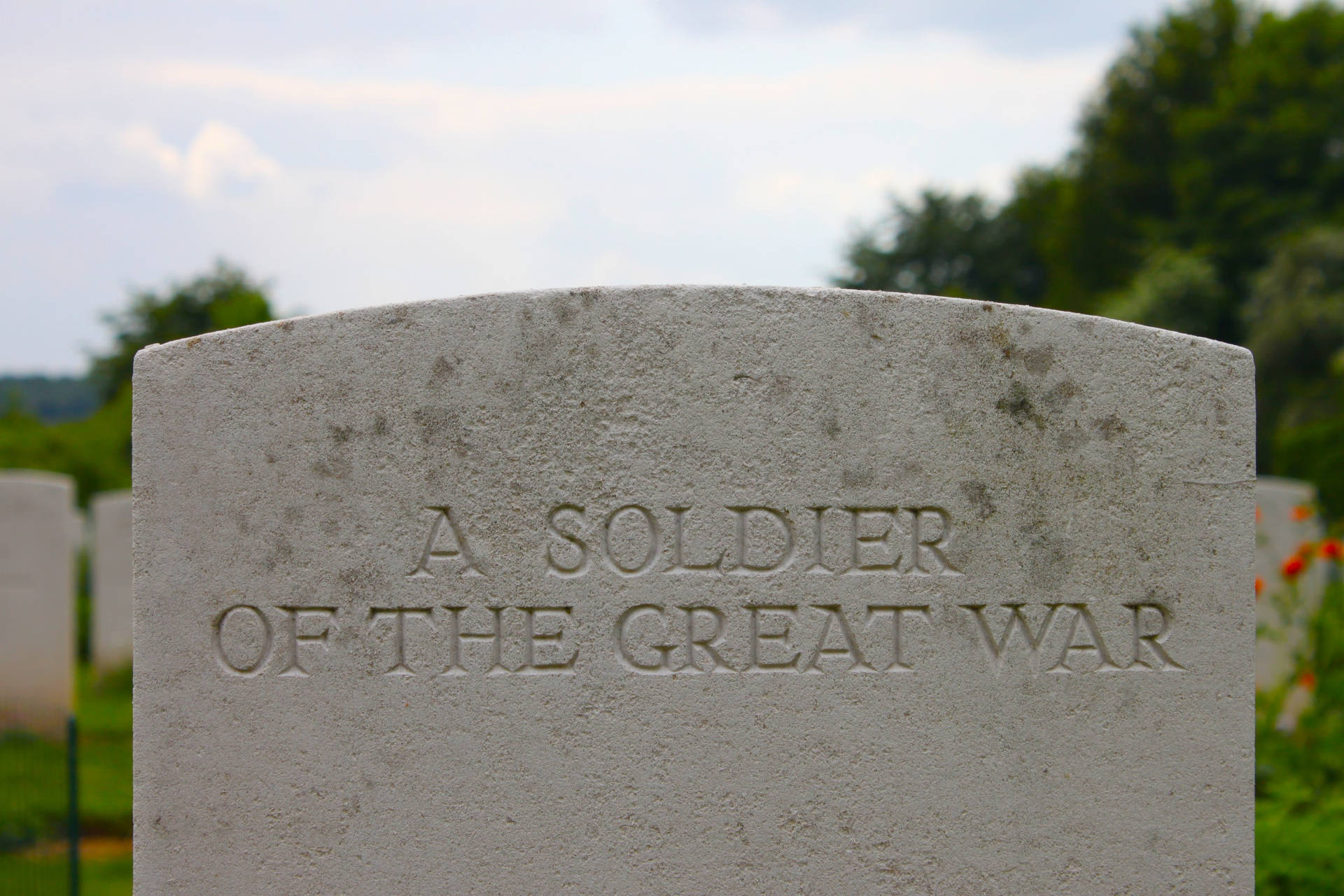 風化的墓碑，刻有「A SOLDIER OF THE GREAT WAR」，位於寧靜的墓園。