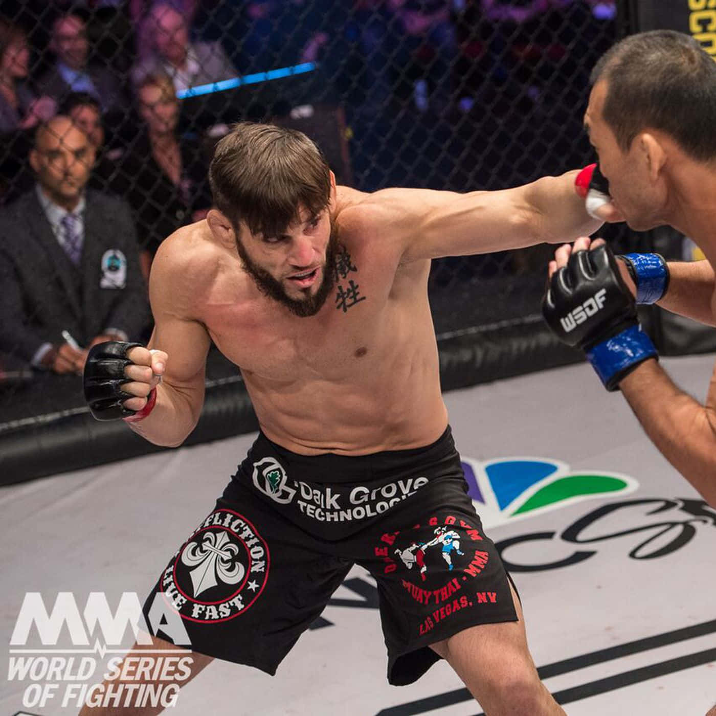 約恩·菲奇對決布萊恩·福斯特 Professional Fighters League 壁紙 — 一位肌肉發達的MMA拳手在明亮的八角籠內，於一場競技比賽中向對手打出強力一拳。