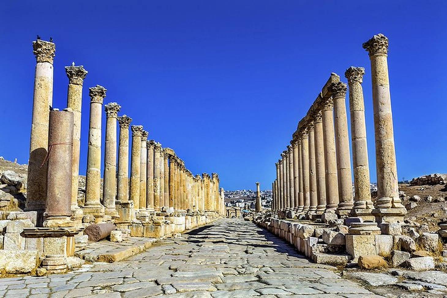 古代石柱在陽光明媚的考古遺址中高高聳立。
