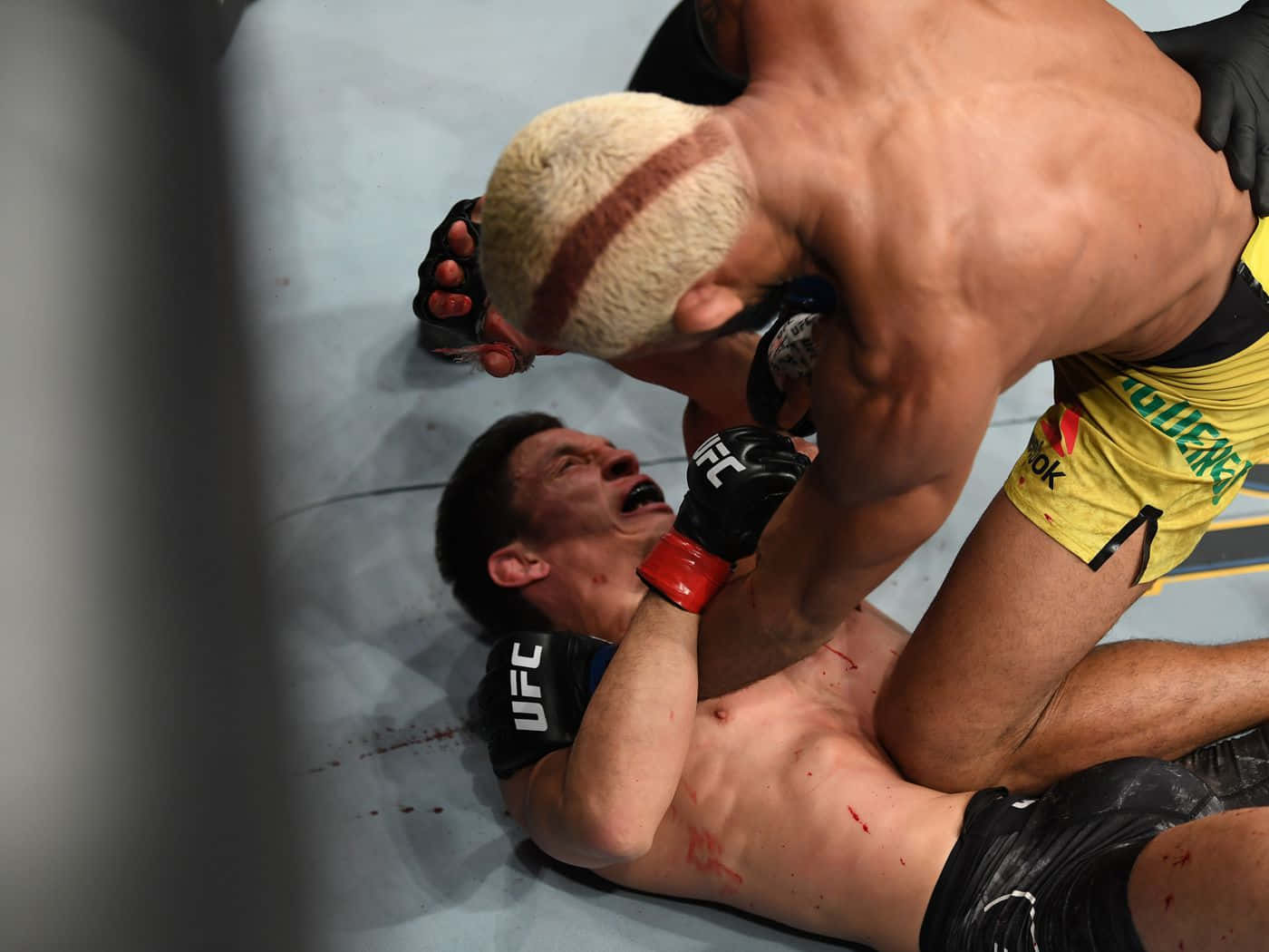 兩名MMA拳手在UFC比賽中鎖喉，墊上有血跡。