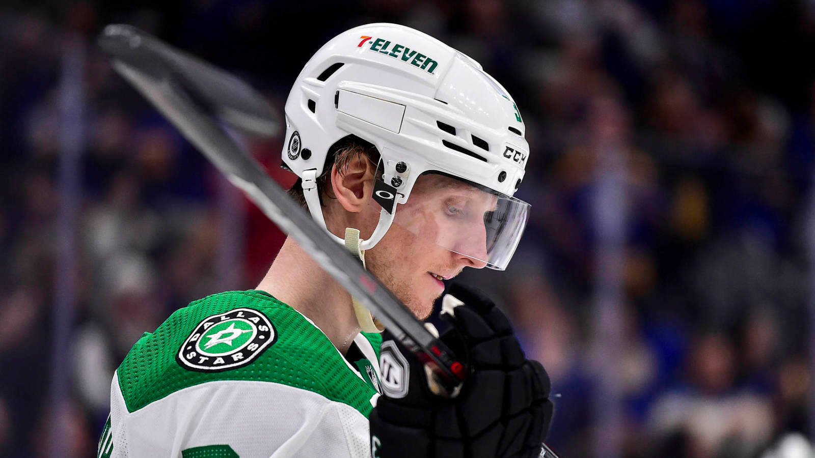 約翰·克林格伯格達拉斯星隊NHL冰球 壁紙 — 達拉斯星隊冰球球員身穿白色頭盔和綠色球衣，在比賽中手持球桿的特寫。