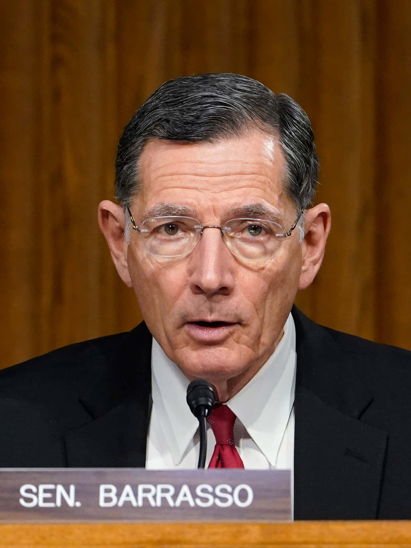 參議員Tom Barrasso在正式聽證會上發言，戴著眼鏡和紅色領帶。