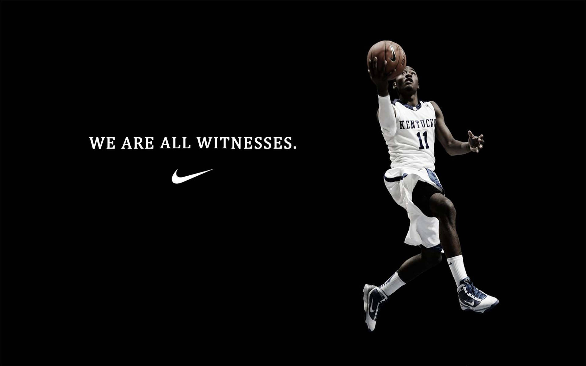 身穿白色球衣的籃球運動員在空中持球，帶有Nike標語。