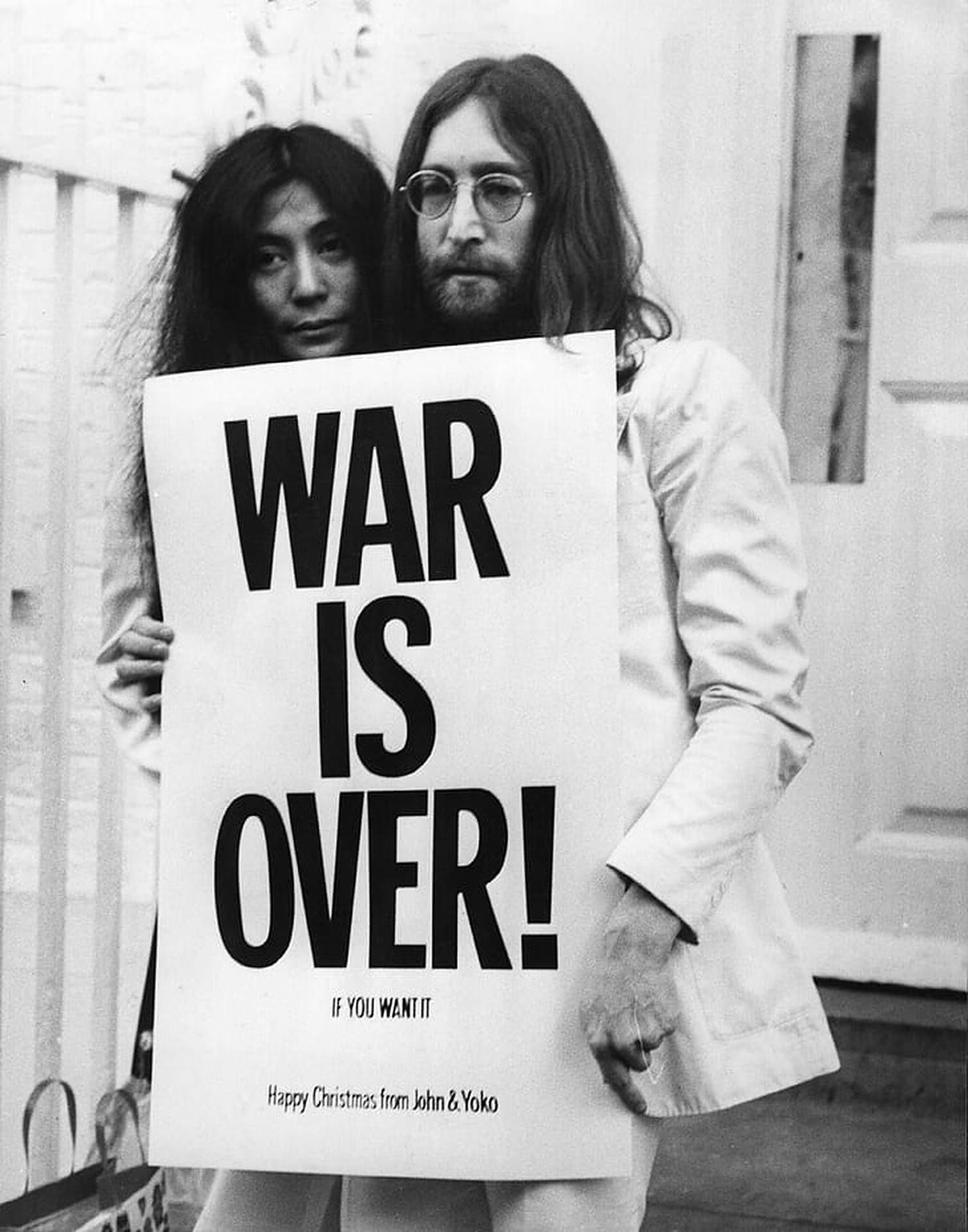 約翰·連儂和小野洋子手持「War Is Over!」抗議標語牌。 — 約翰·連儂 GIF 壁紙