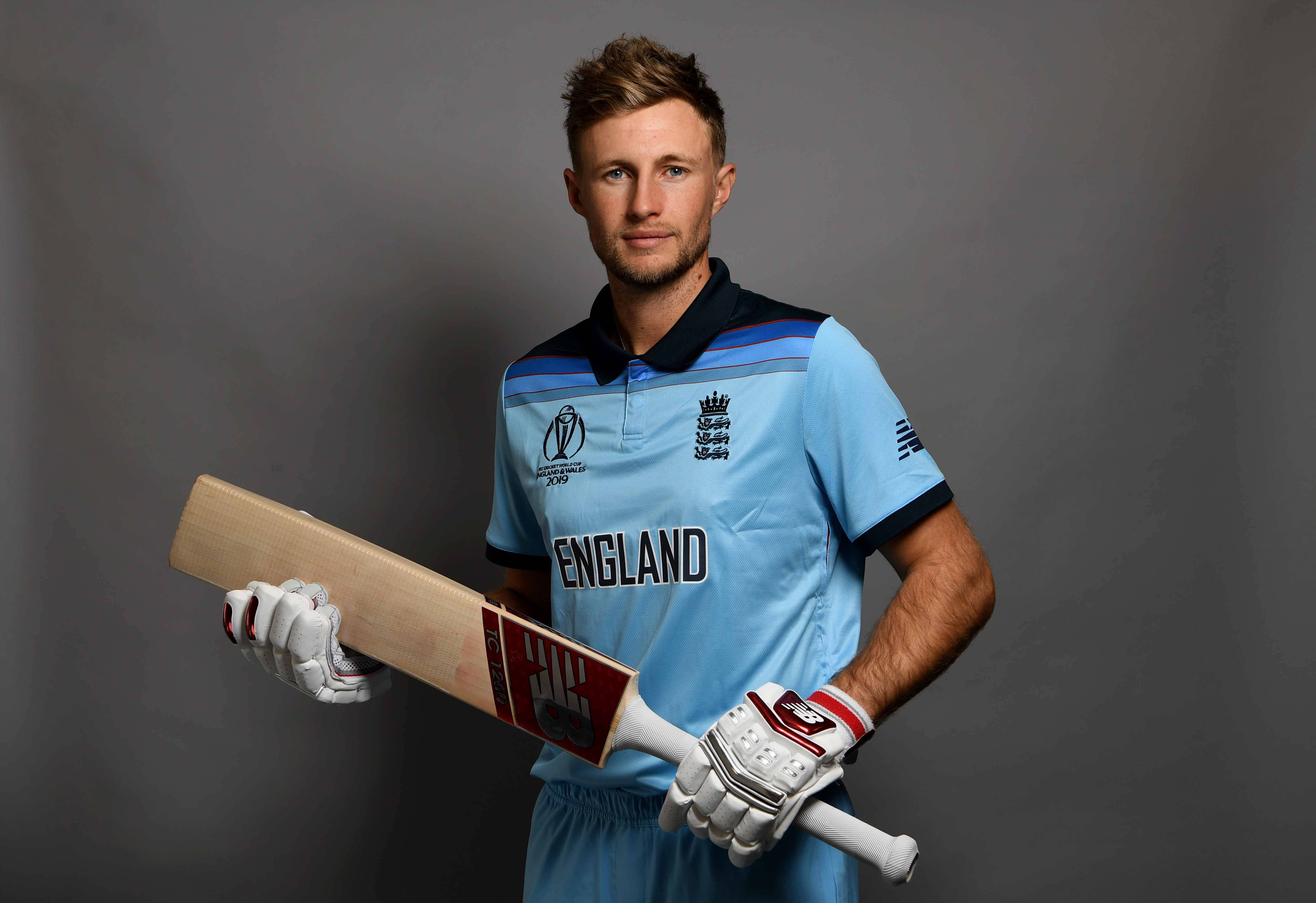 約翰·魯特肖像 壁紙 — 一名身穿英格蘭球衣的男性板球運動員在純灰色攝影棚背景前手持球棒。