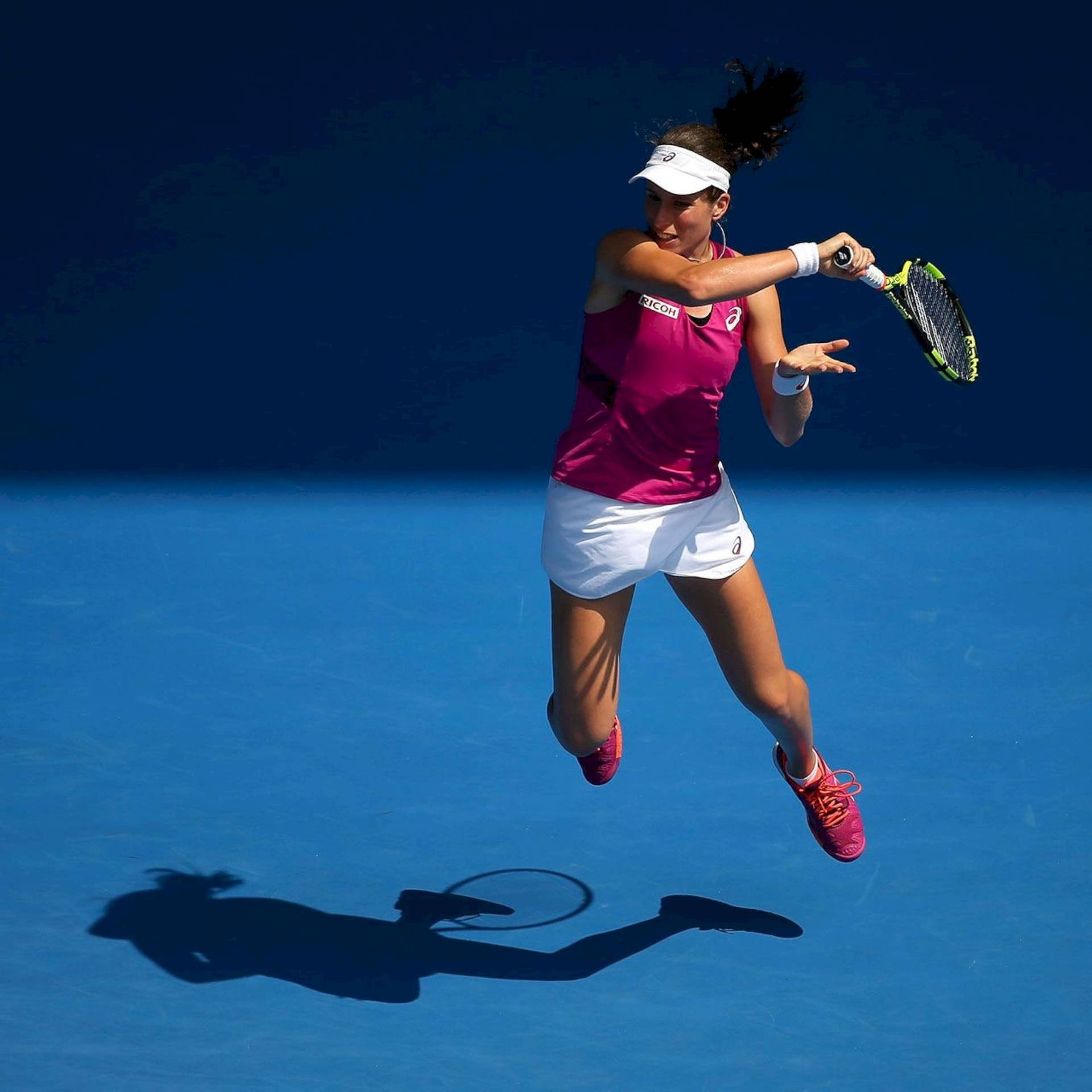 網球手在藍色球場上跳起擊球