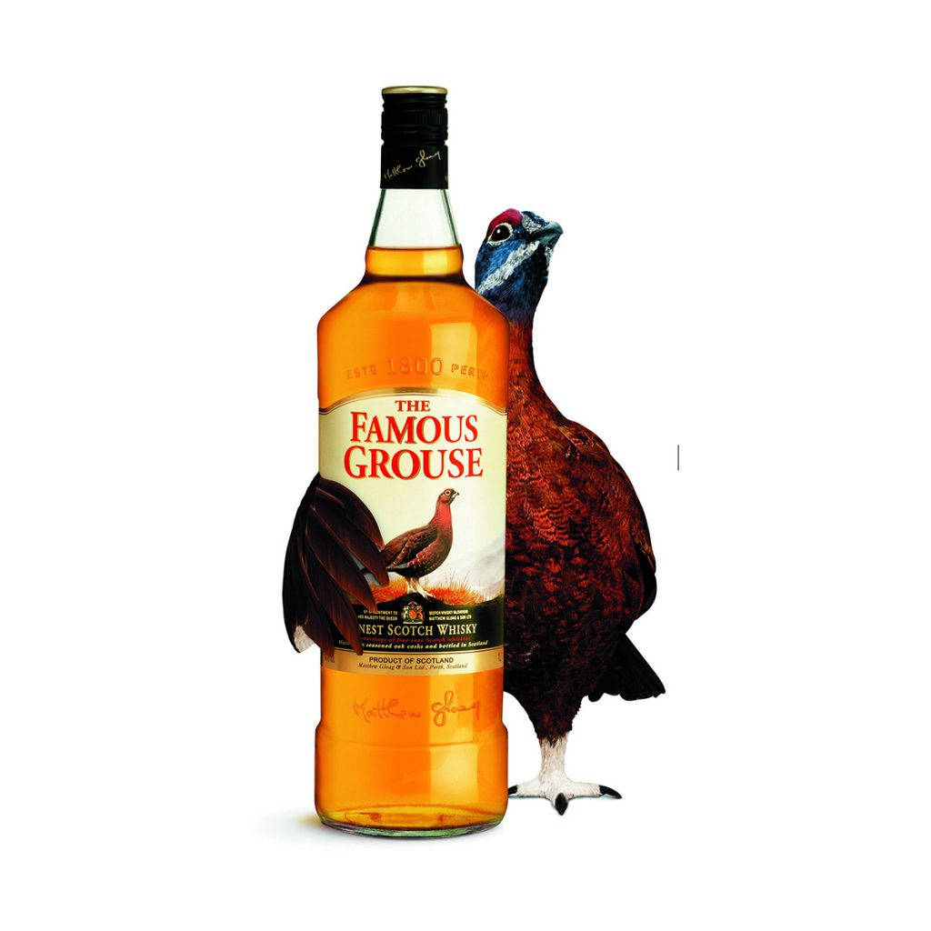 一瓶 Famous Grouse 威士忌旁邊有一隻松雞。
