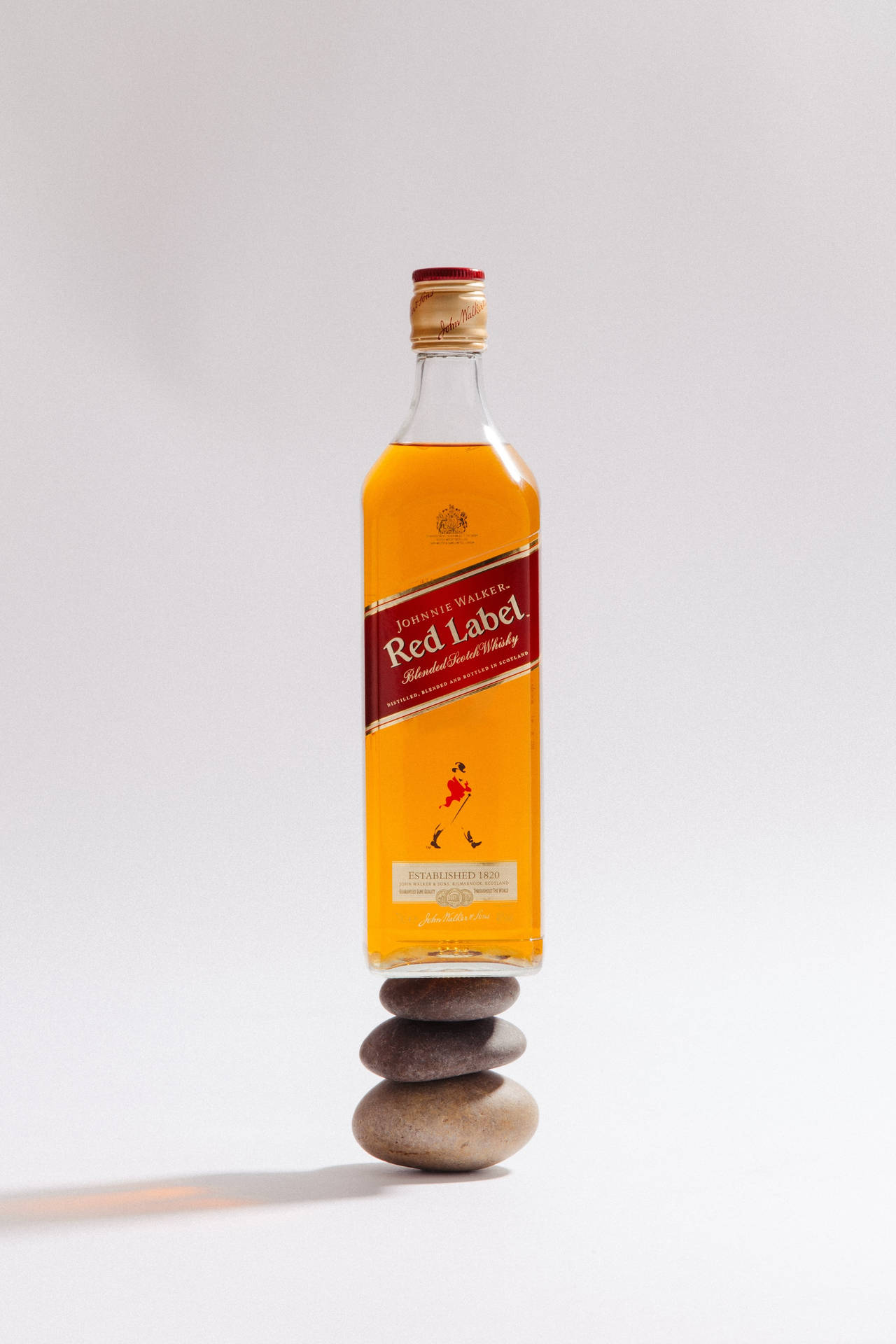 約翰走路紅牌威士忌酒瓶平衡地放在石堆上。