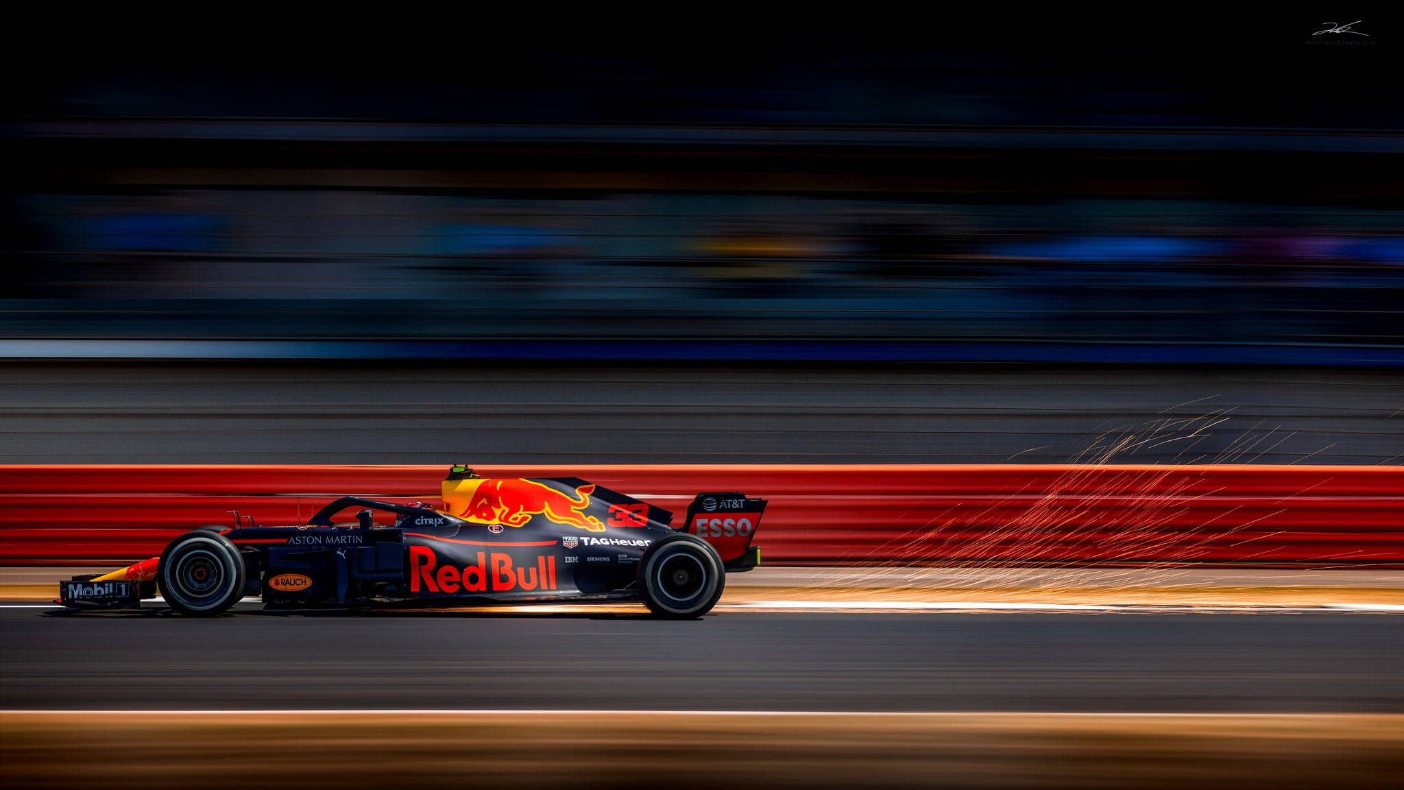 紅牛 F1 RB14 賽車 壁紙 — 一輛紅牛一級方程式賽車在夜間賽道上疾馳而過，帶有動態模糊效果，輪胎迸發出火花。