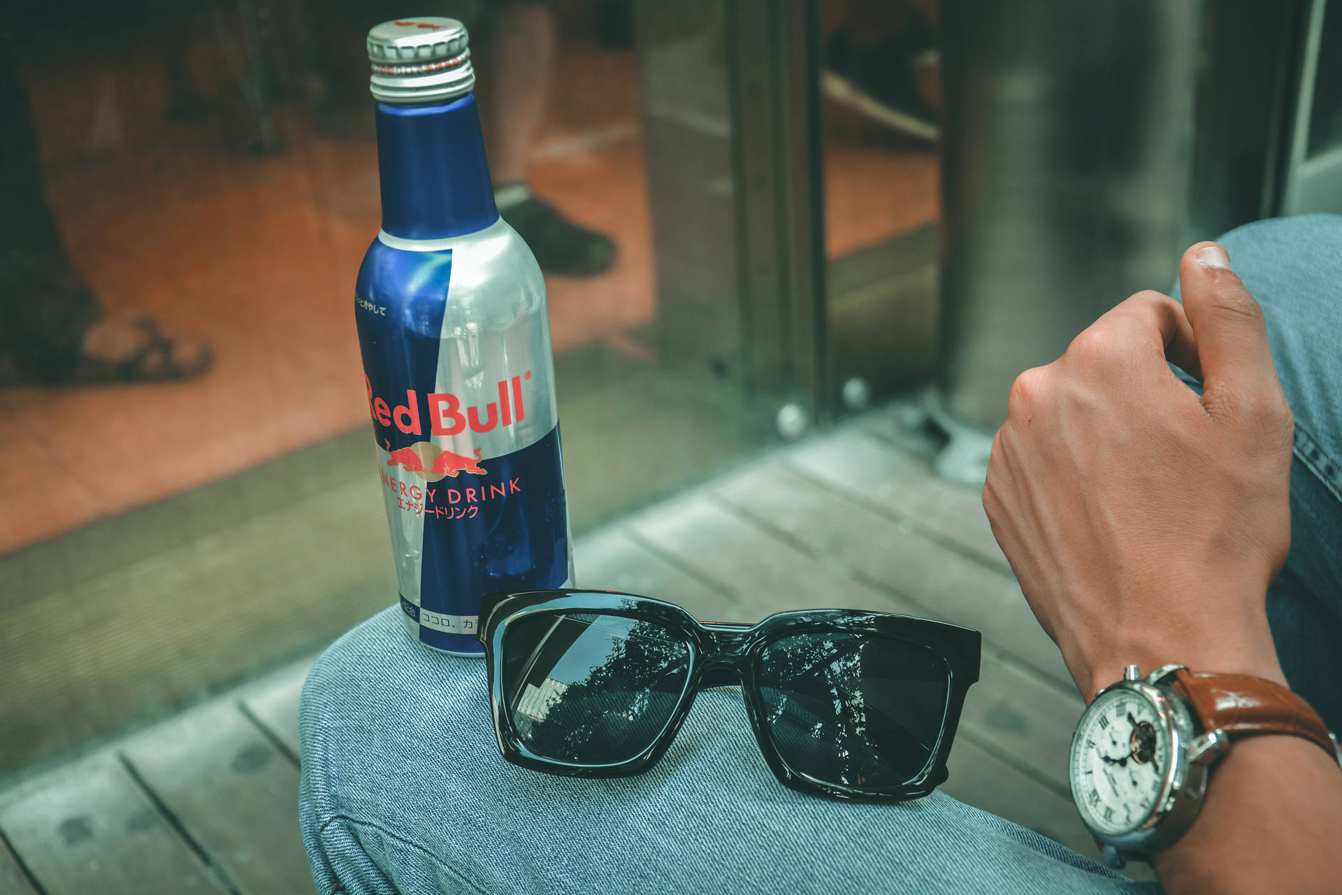 Red Bull 瓶 太陽眼鏡 手錶 牛仔褲腿 玻璃門