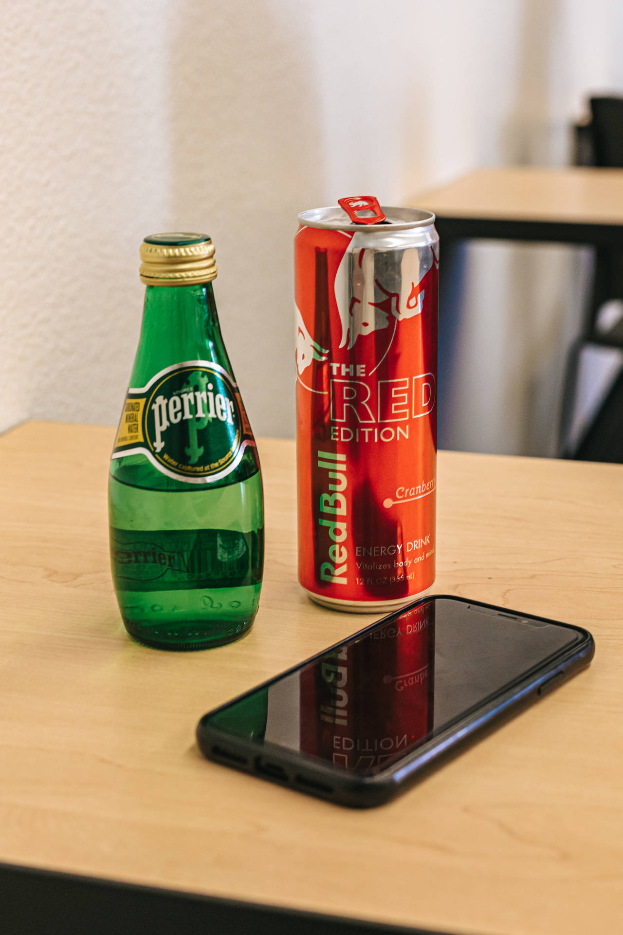 Perrier瓶和Red Bull罐與手機在木桌上