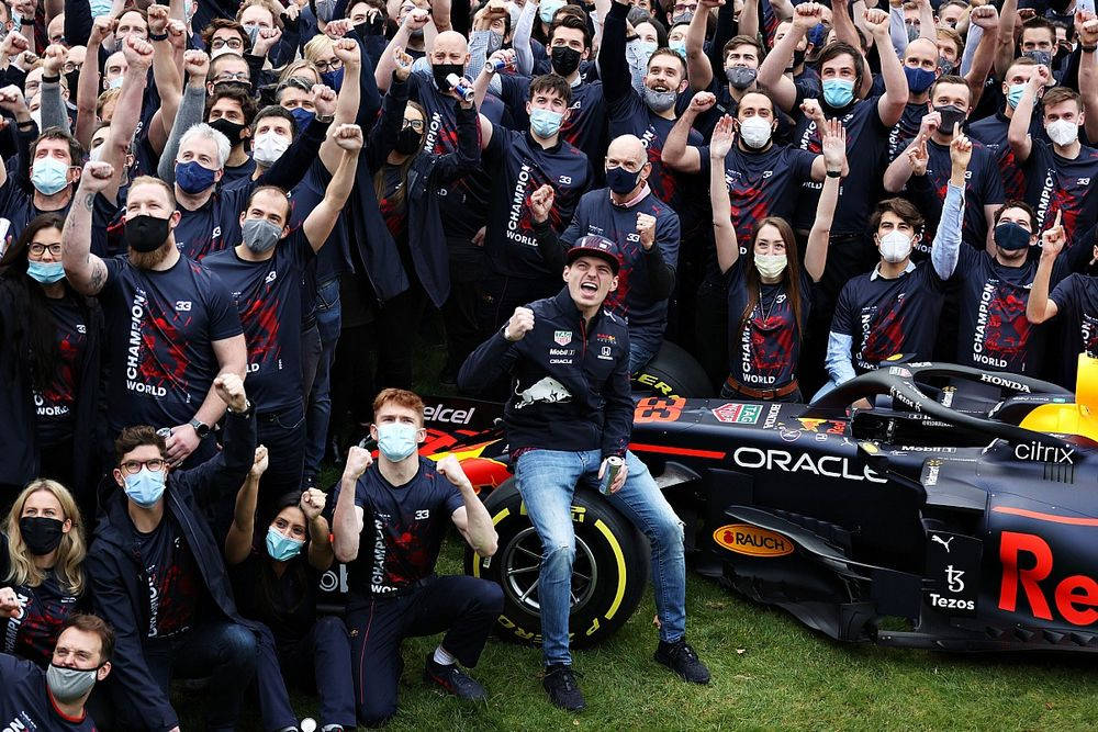 F1車隊和車手在草地上舉起拳頭慶祝錦標賽勝利。