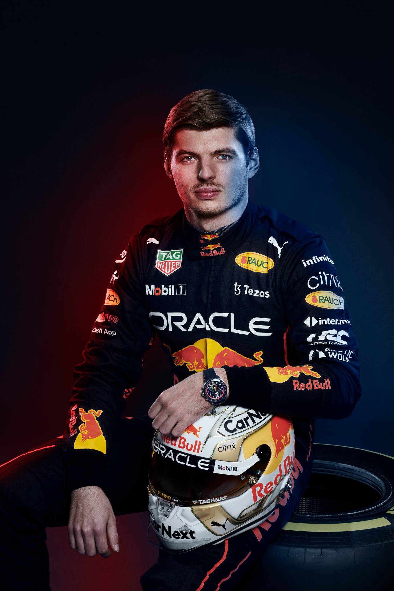 身穿紅牛賽車裝備的F1車手在工作室中手持頭盔