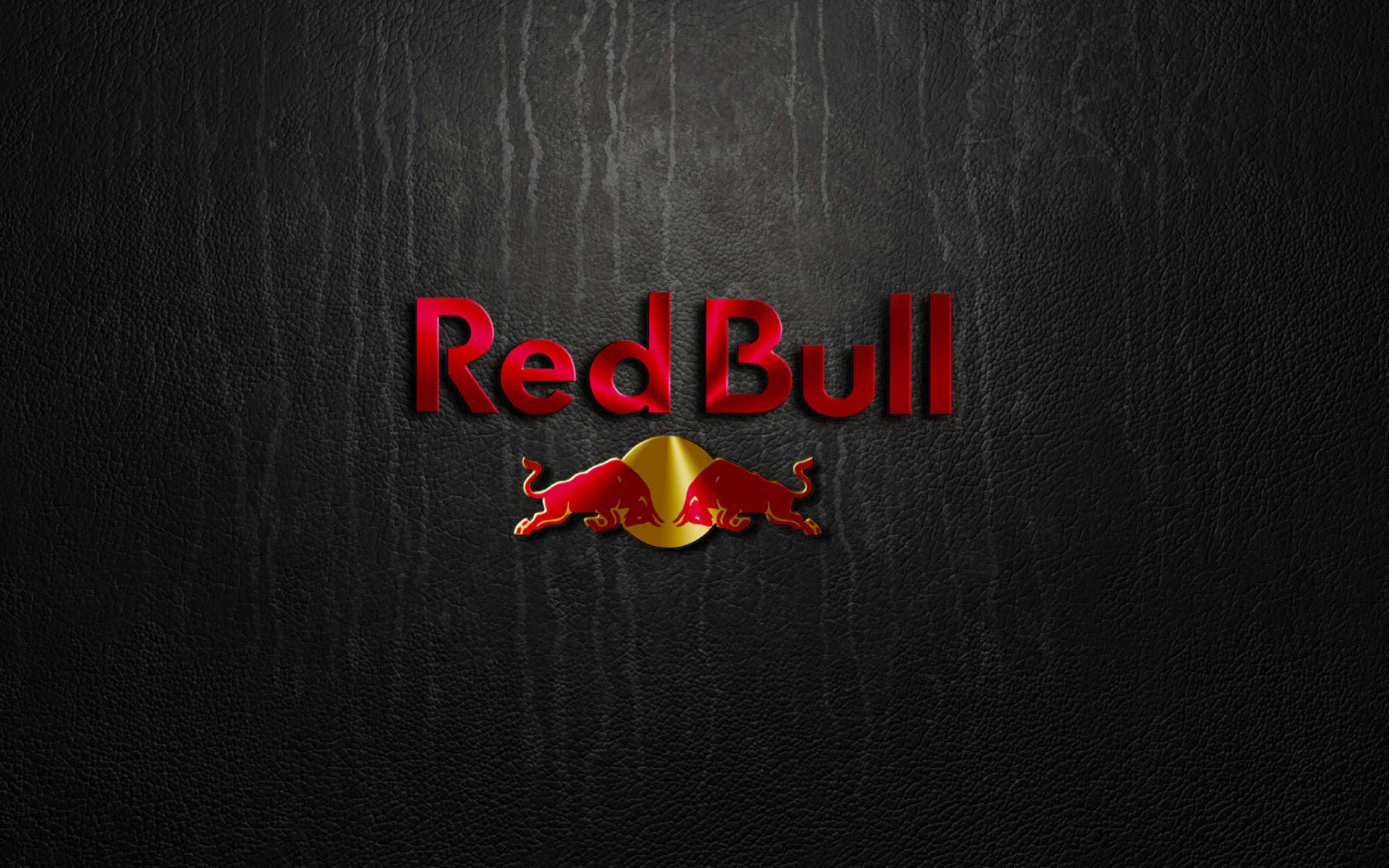 紅牛黑 壁紙 — Red Bull 標誌，兩頭衝鋒的紅色公牛位於金色圓圈中央，背景為深色紋理皮革。