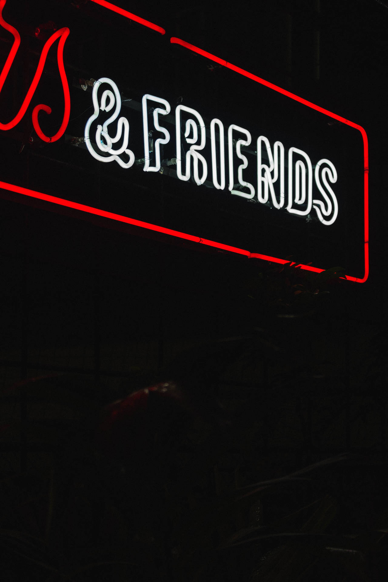 夜晚以白色和紅色邊框顯示 & FRIENDS 的霓虹燈牌。