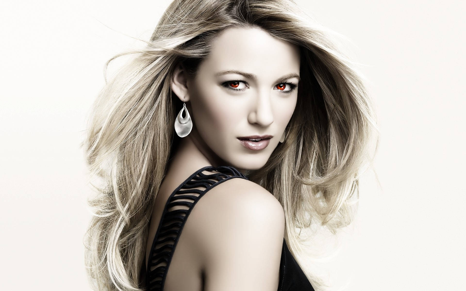 紅眼 Blake Lively 壁紙 — 一位迷人的金髮女性，擁有引人注目的紅眼睛和飄逸的頭髮，穿著黑色連衣裙，在柔和的白色背景前自信地擺姿勢。