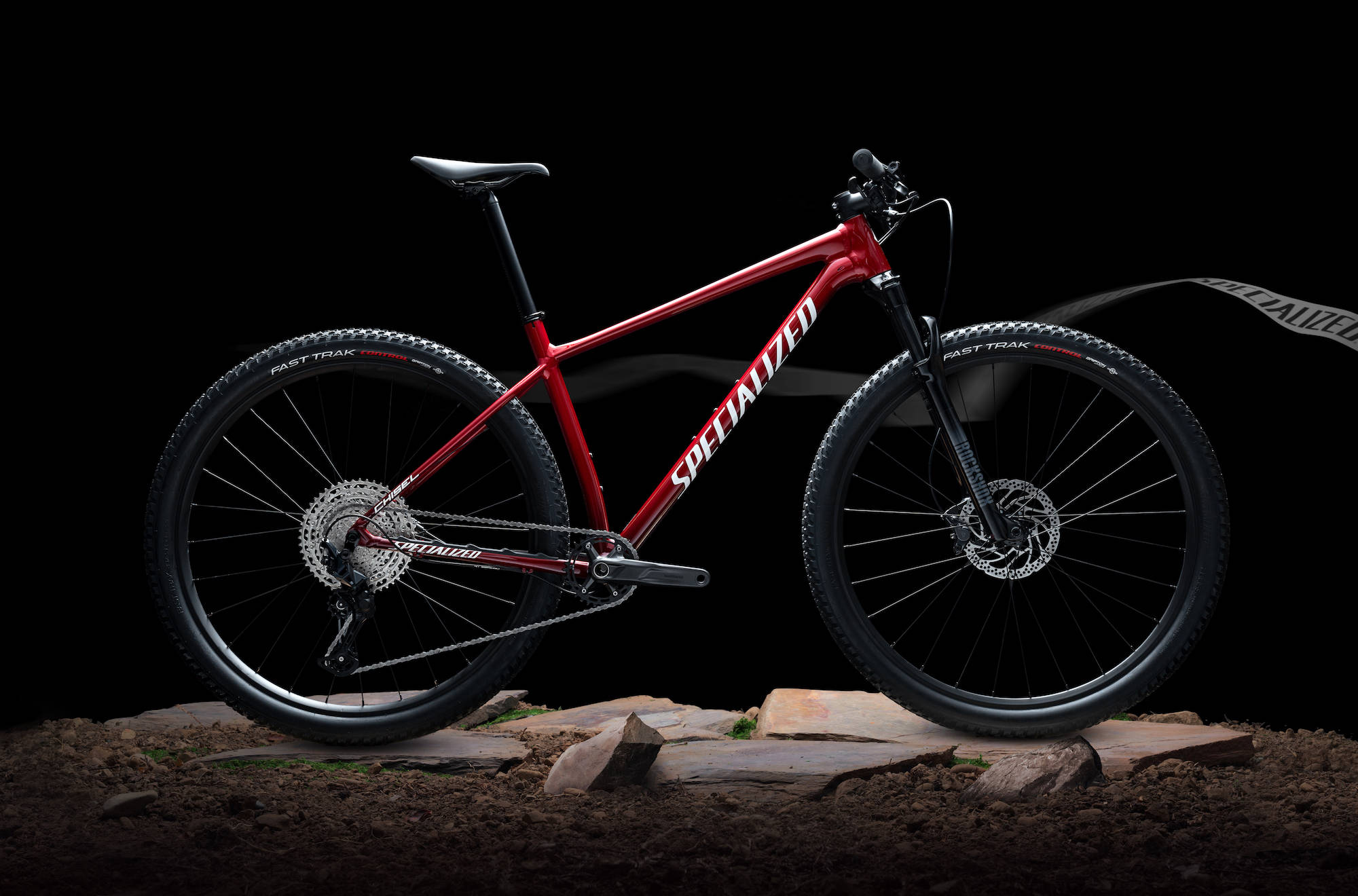紅色 Specialized 自行車 壁紙 — 一架時尚的紅色Specialized山地單車在崎嶇地形上，以黑色背景襯托。