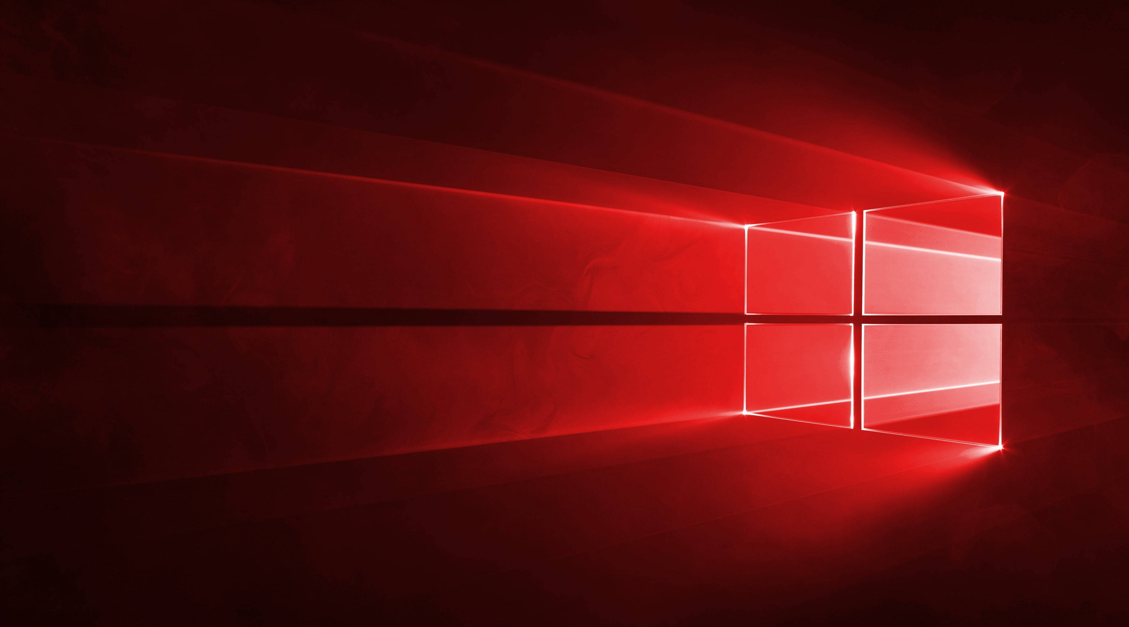 紅色 Windows 標誌專業桌面壁紙 壁紙 — 一個發光的紅色窗戶標誌在極簡數位藝術場景中，將耀眼的光束投射到深色紋理牆壁上。