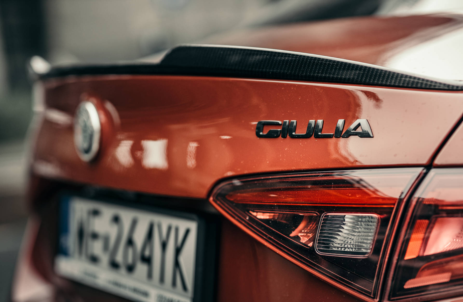 紅色Alfa Romeo Giulia車尾特寫，帶碳纖維尾翼和尾燈。
