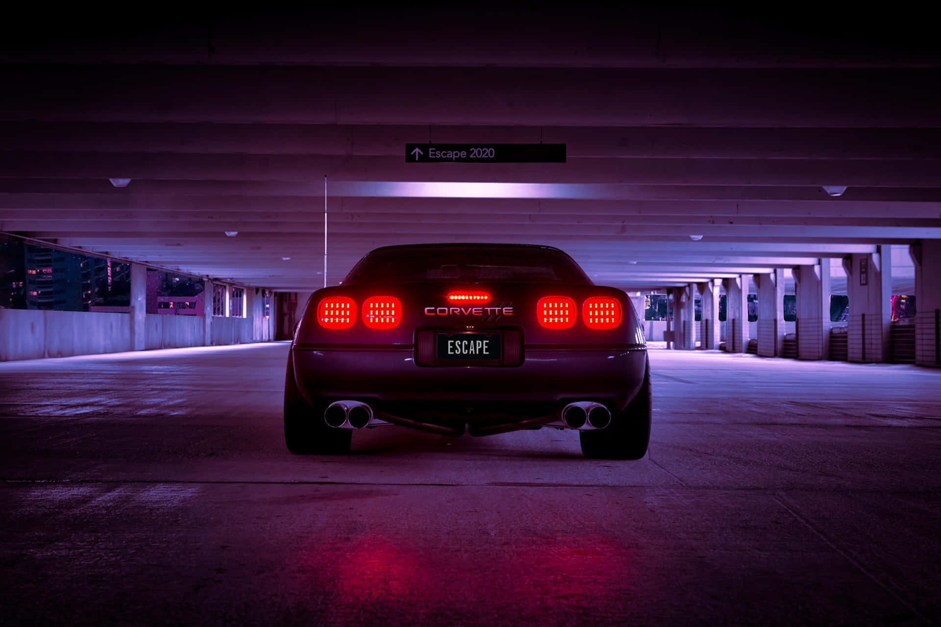 黑色Corvette帶紅色尾燈，停放在昏暗的紫色停車場中。