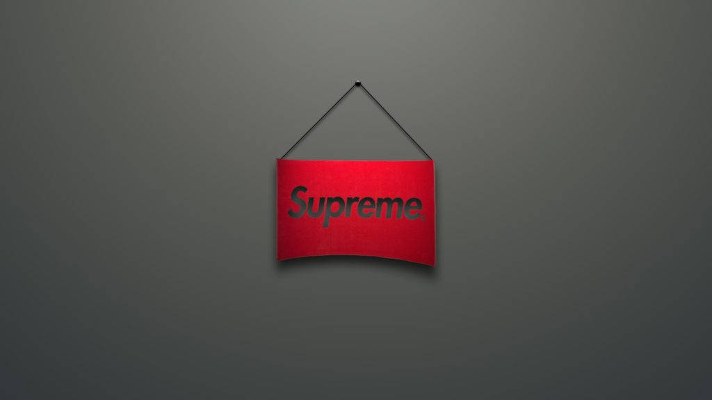 紅色Supreme標誌灰底 壁紙 — 一個紅色Supreme標誌招牌掛在純深灰色牆壁中央，光線柔和。
