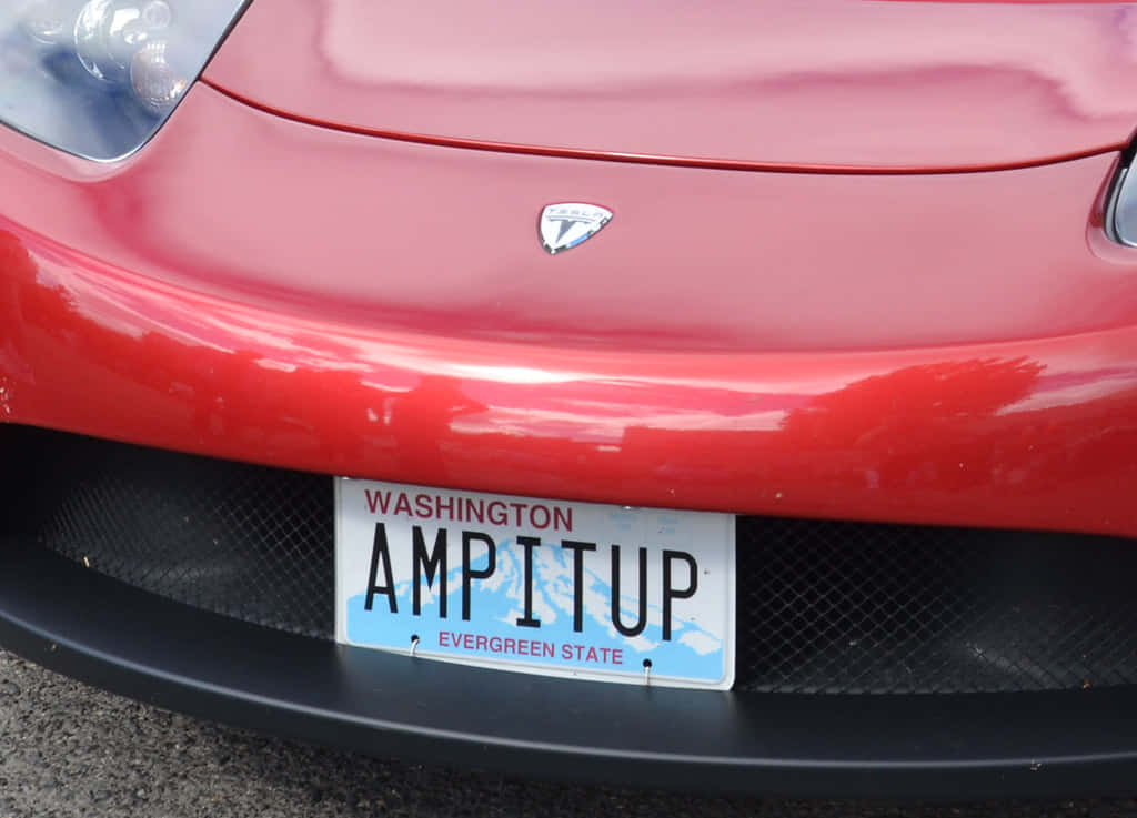 Car License Plate 桌布 壁紙 — 紅色Tesla車頭泵把特寫，帶有華盛頓州車牌，上面寫著AMPITUP。