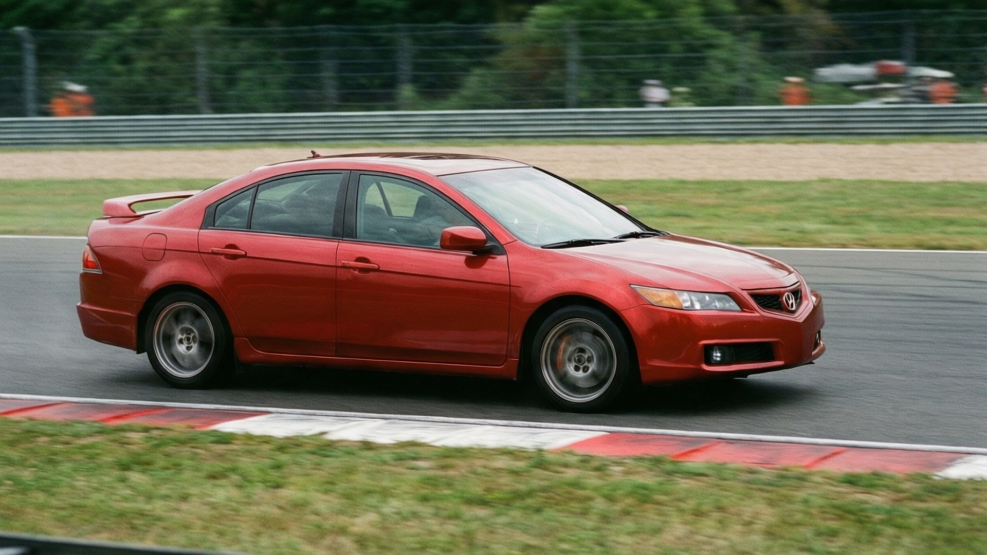 紅色Acura TSX房車在賽道上疾馳，周圍模糊。