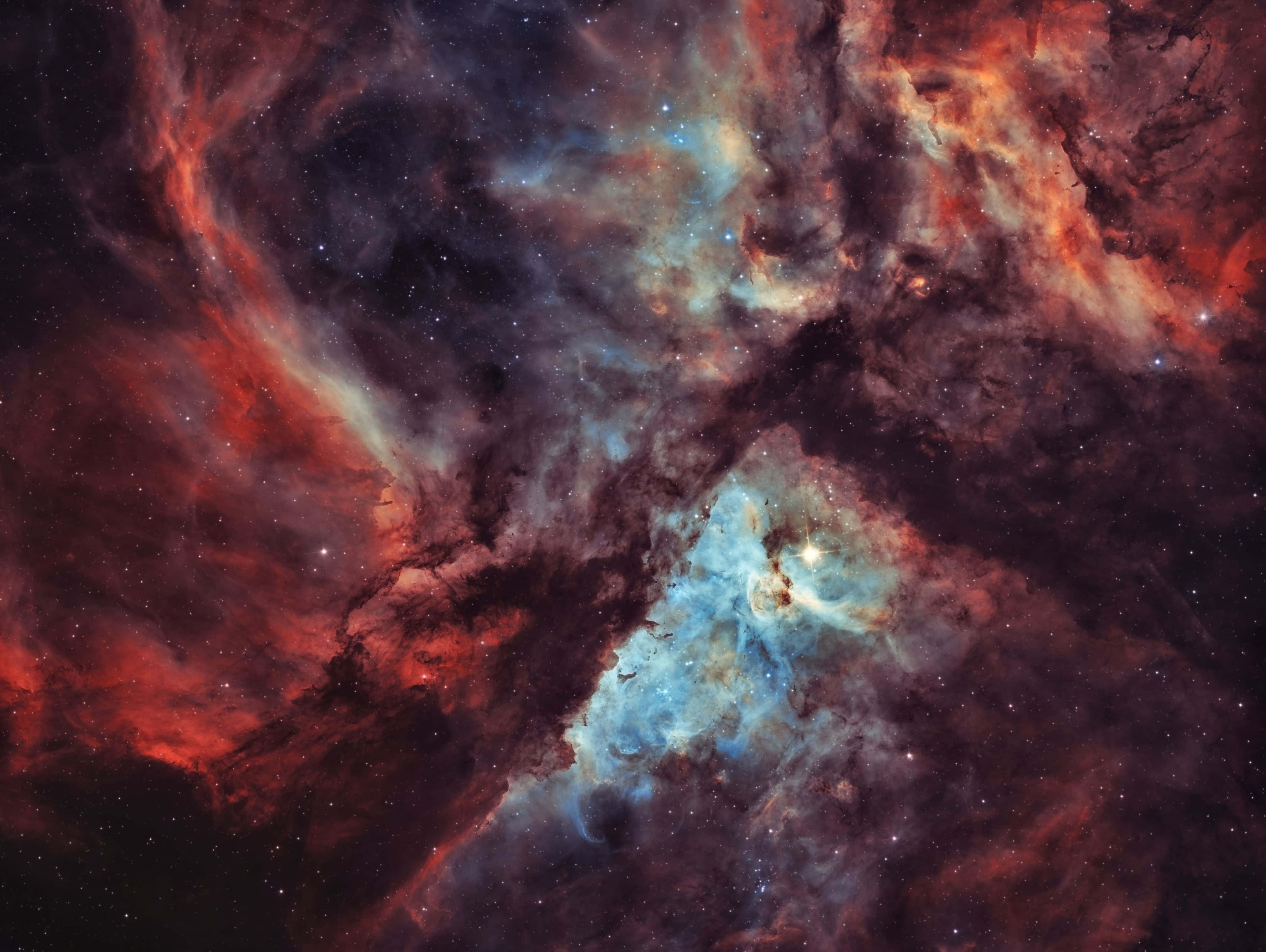 Carina Nebula 桌布 壁紙 — 紅色和藍色氣體組成的充滿活力的宇宙雲團在戲劇性的星雲中圍繞著發光的恆星旋轉。