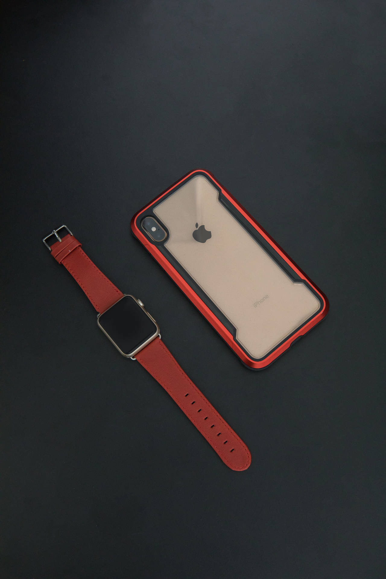 紅色 Apple Watch 和 iPhone 保護殼在深色背景上