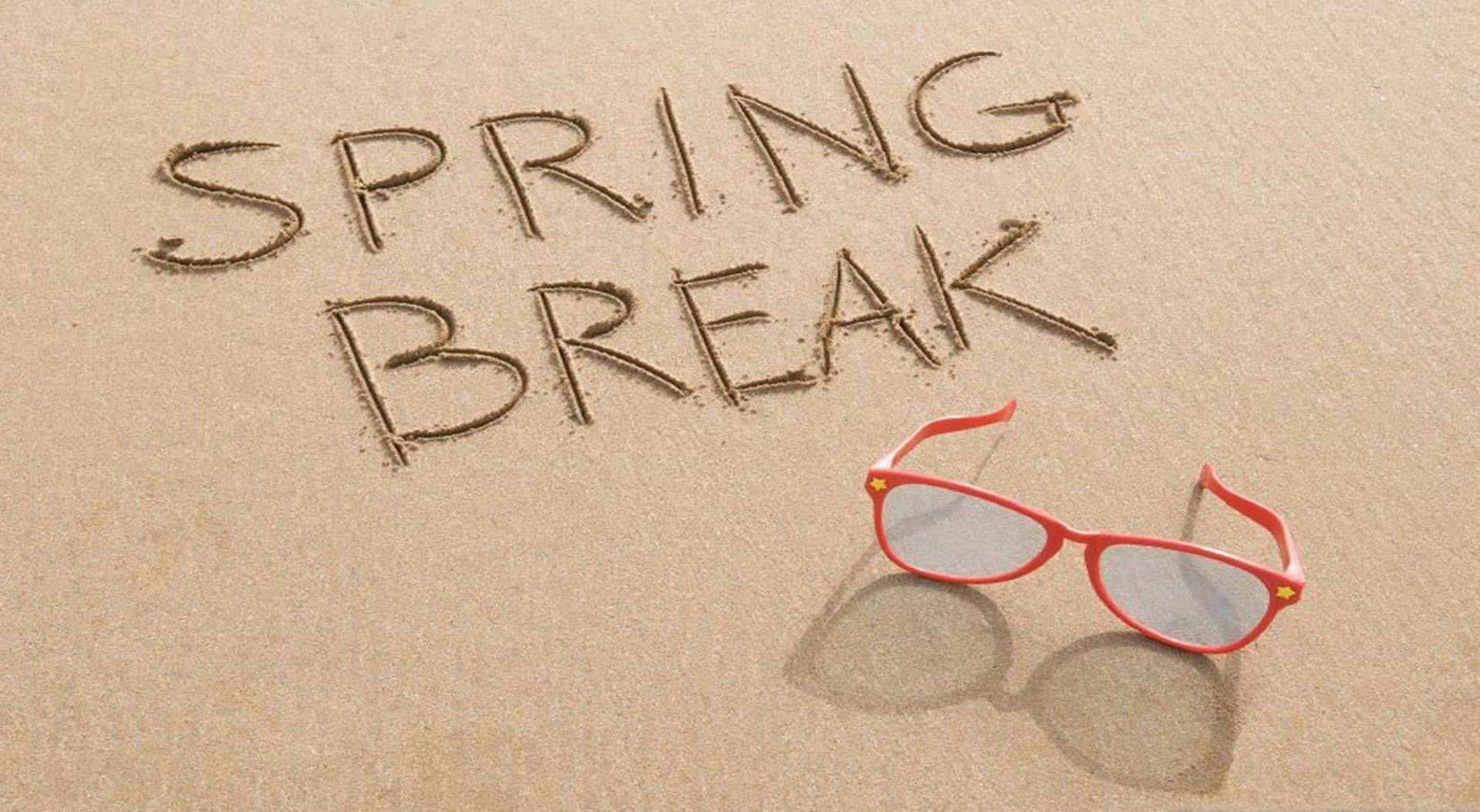 Spring Vacation 桌布 壁紙 — 紅色太陽眼鏡擱在溫暖的沙上，旁邊以鬆散字體寫着「SPRING BREAK」。