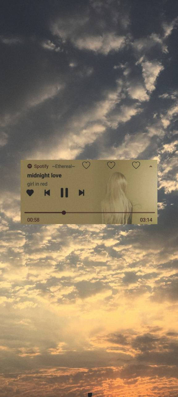 Spotify 音樂播放器漂浮在帶有雲朵的日落天空上。